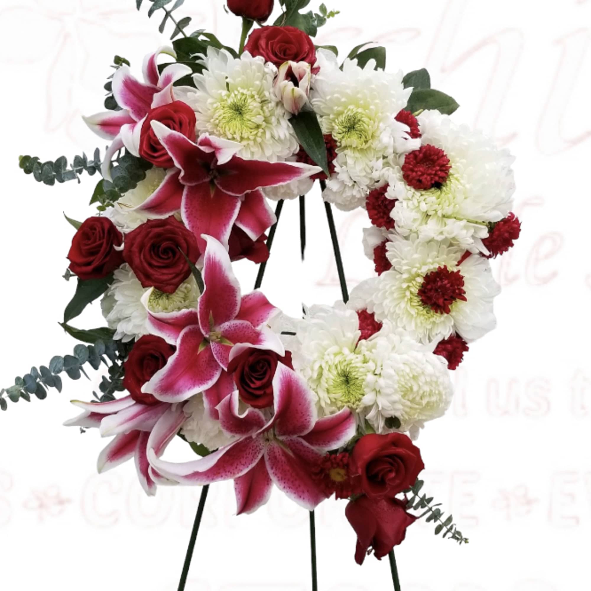 Heart-shaped floral wreath with red roses, pink lilies, and white chrysanthemums