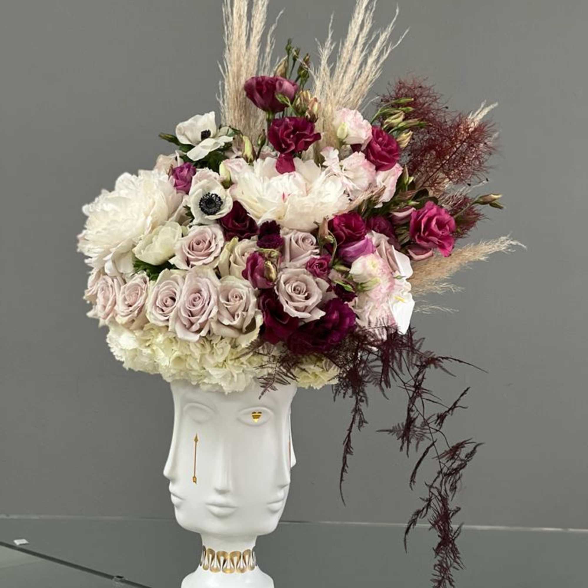 Floral arrangement in a white sculptural vase with pink and white blooms