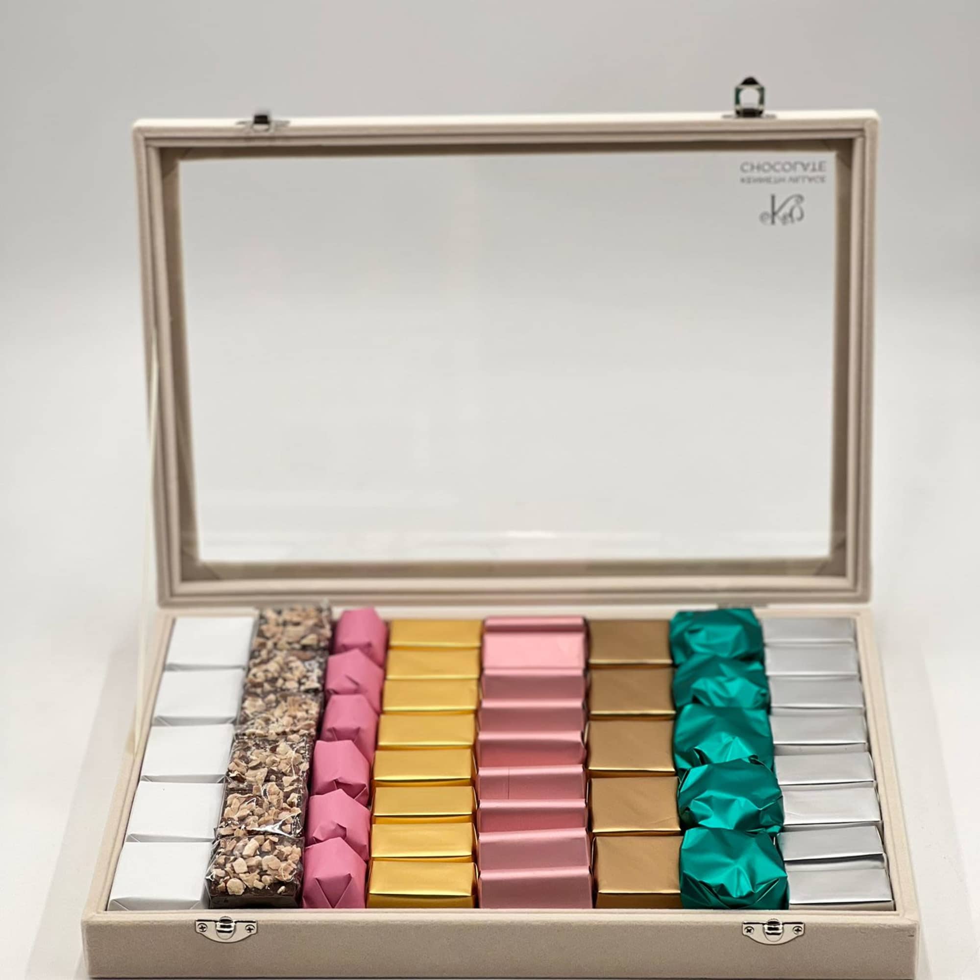 Open gift box with assorted wrapped chocolates in neat rows