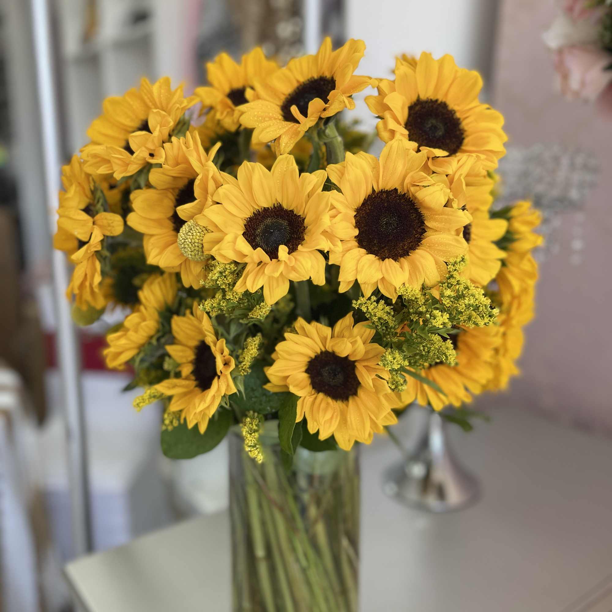 Bouquet of yellow sunflowers in a clear glass vase