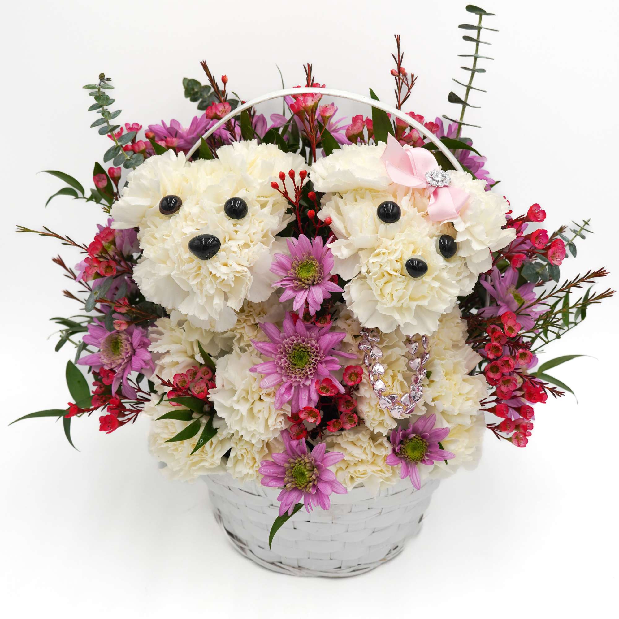 Basket arrangement of white carnations shaped like teddy bears with pink flowers
