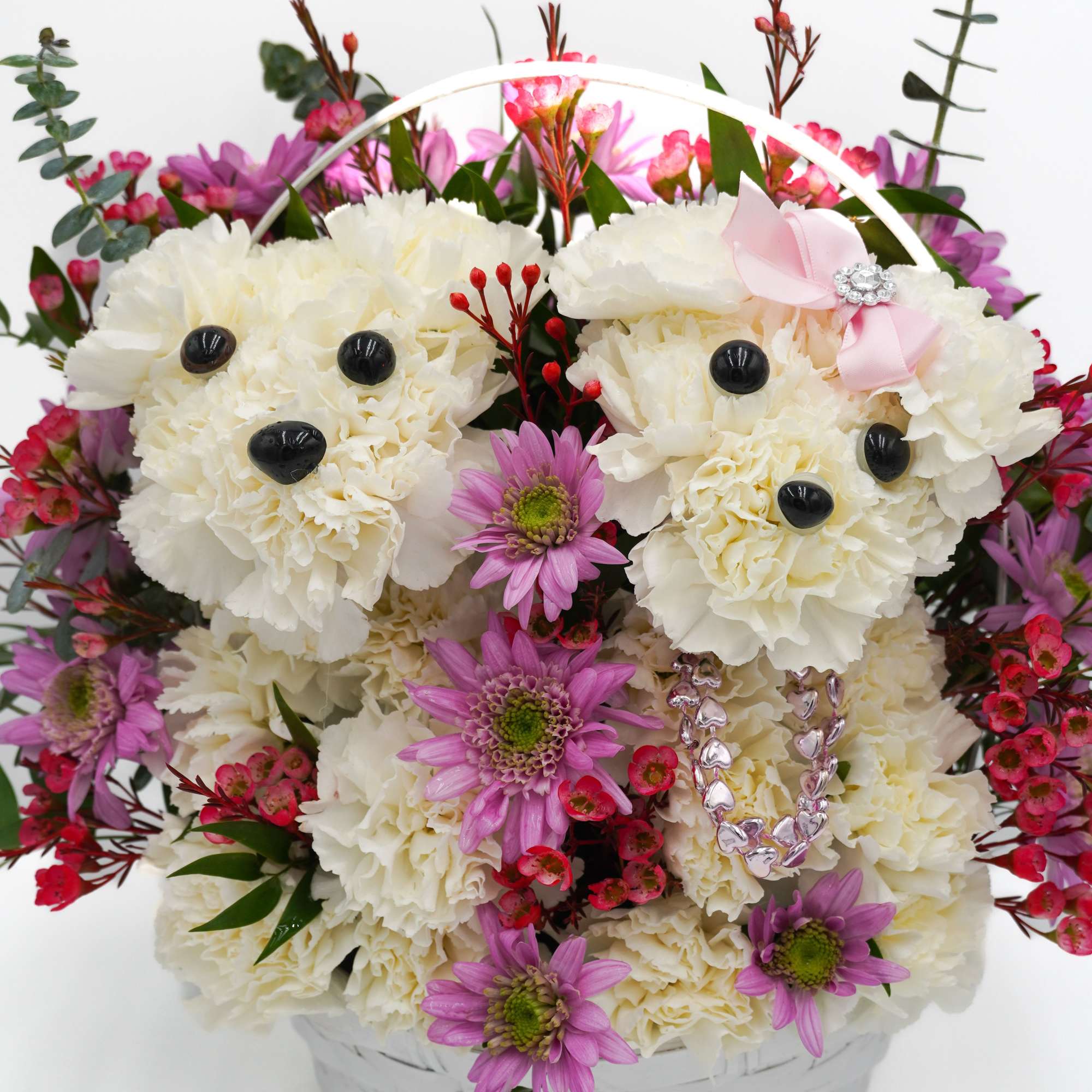 Two adorable puppies made from fresh white carnations in a basket and