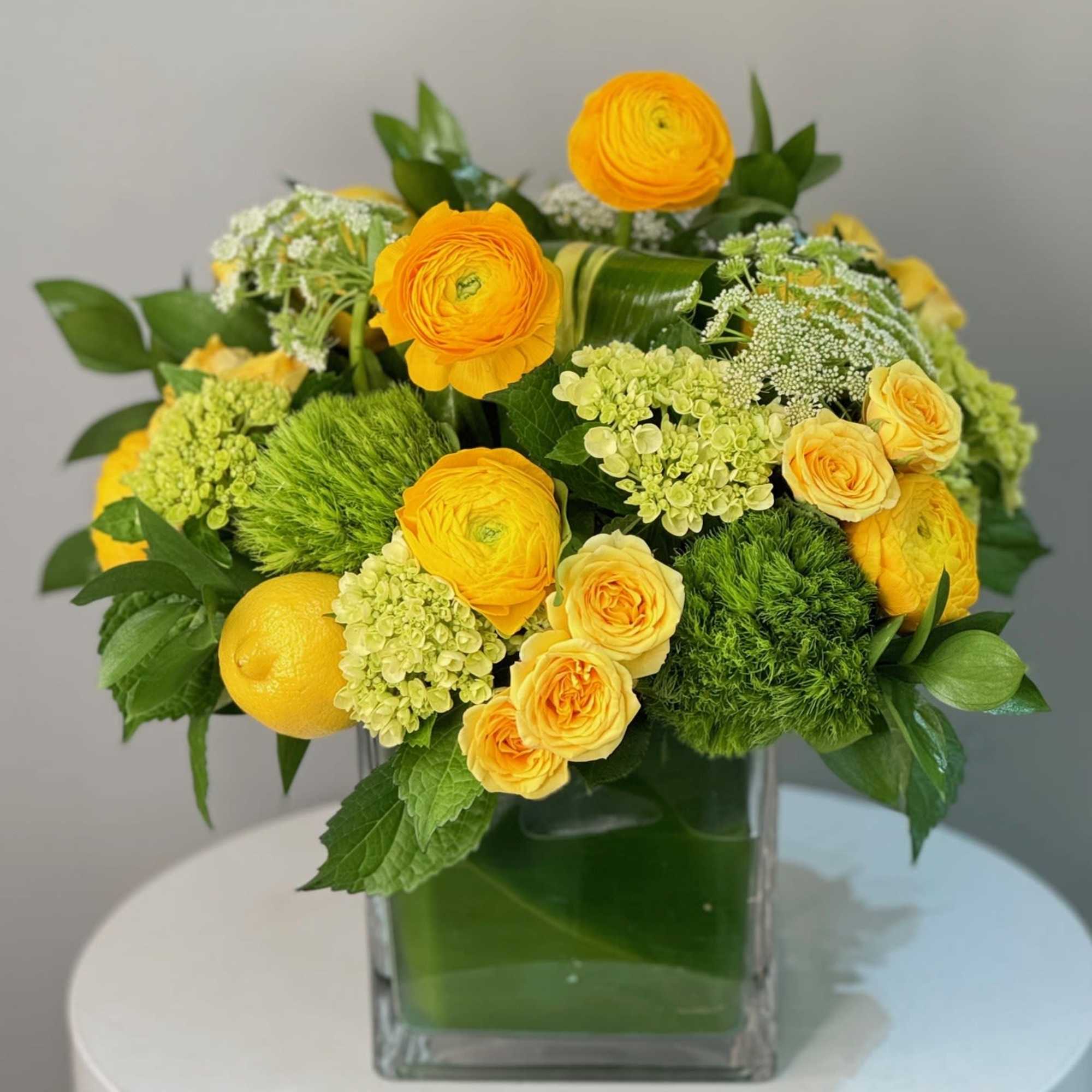 This arrangement bursts with sunny yellow ranunculus and roses, paired with fresh, photo 2 of 2