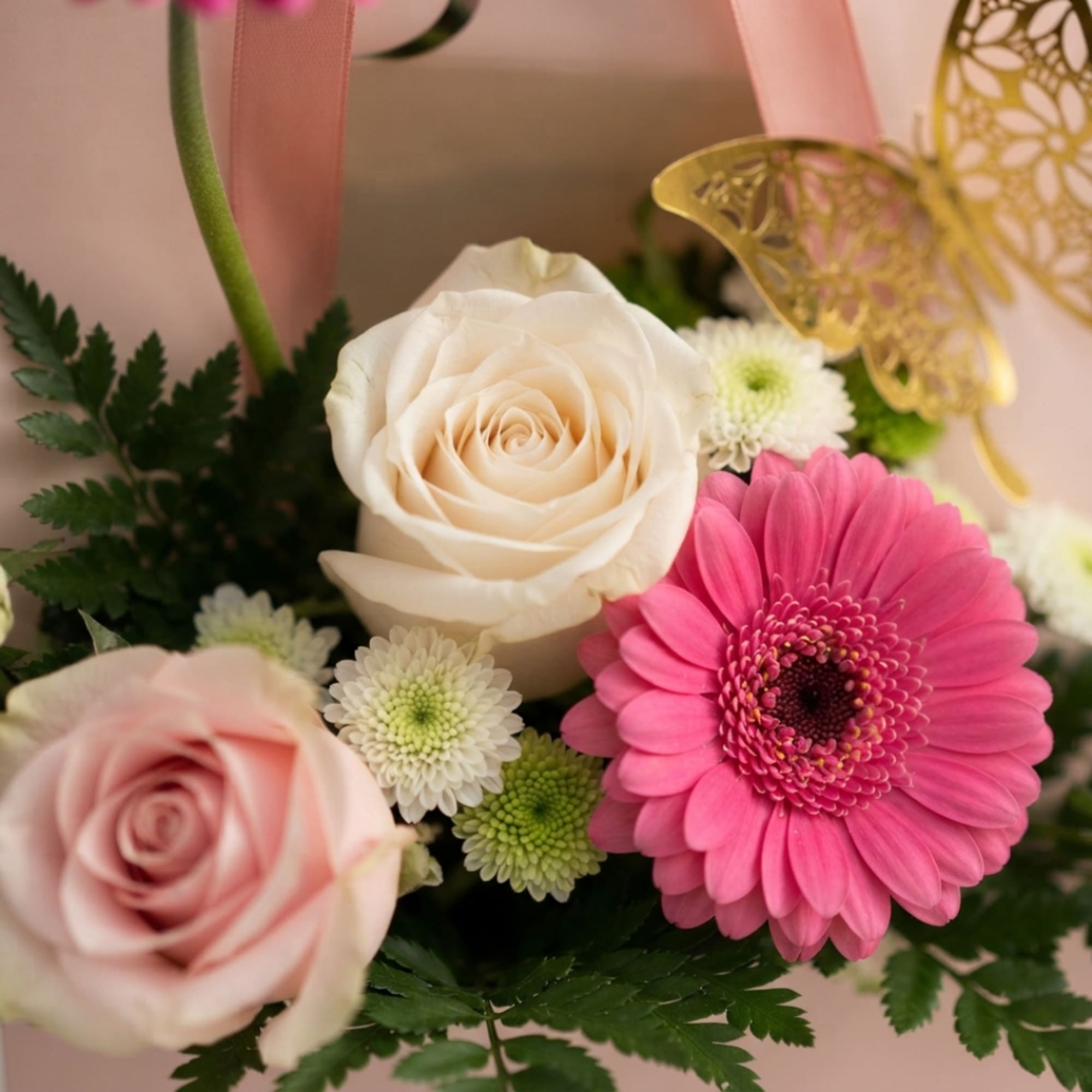 Pink and white floral arrangement with roses and a gerbera daisy