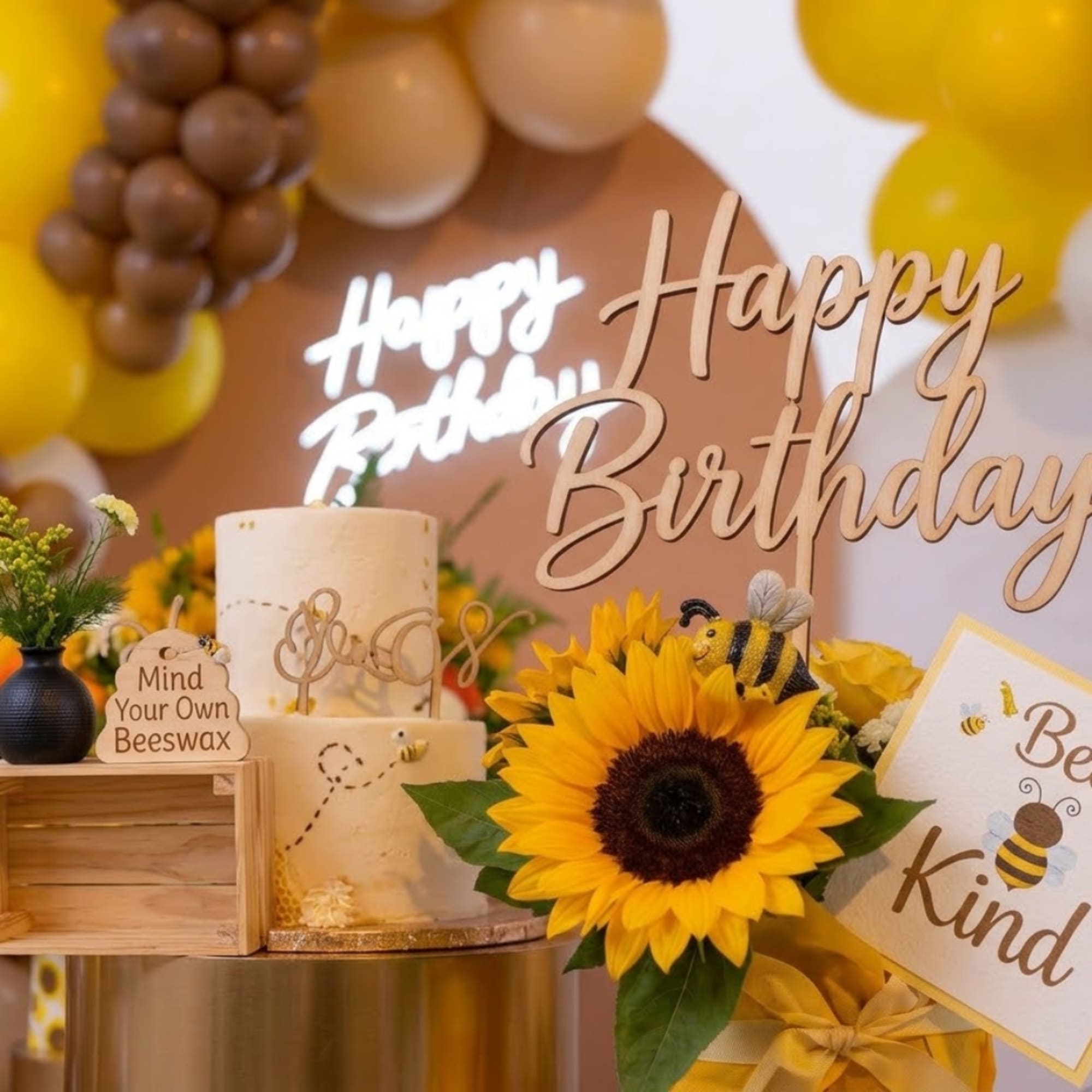 Birthday display with a sunflower, candles, balloons, and bee-themed signs