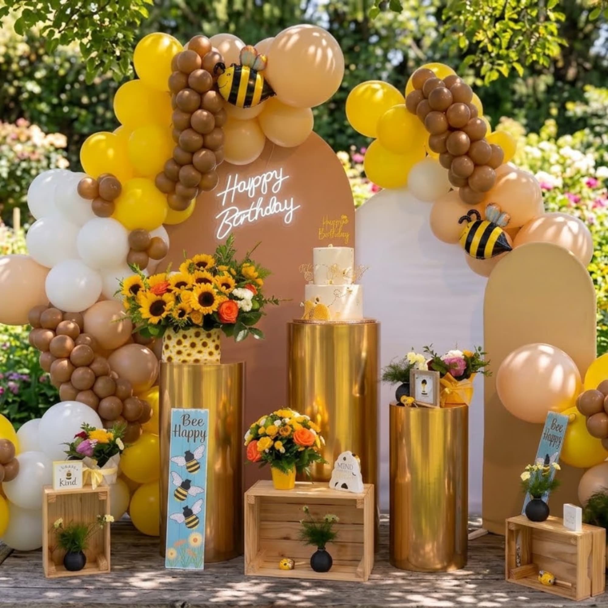 Birthday display with balloon arches, sunflowers, and bee decorations