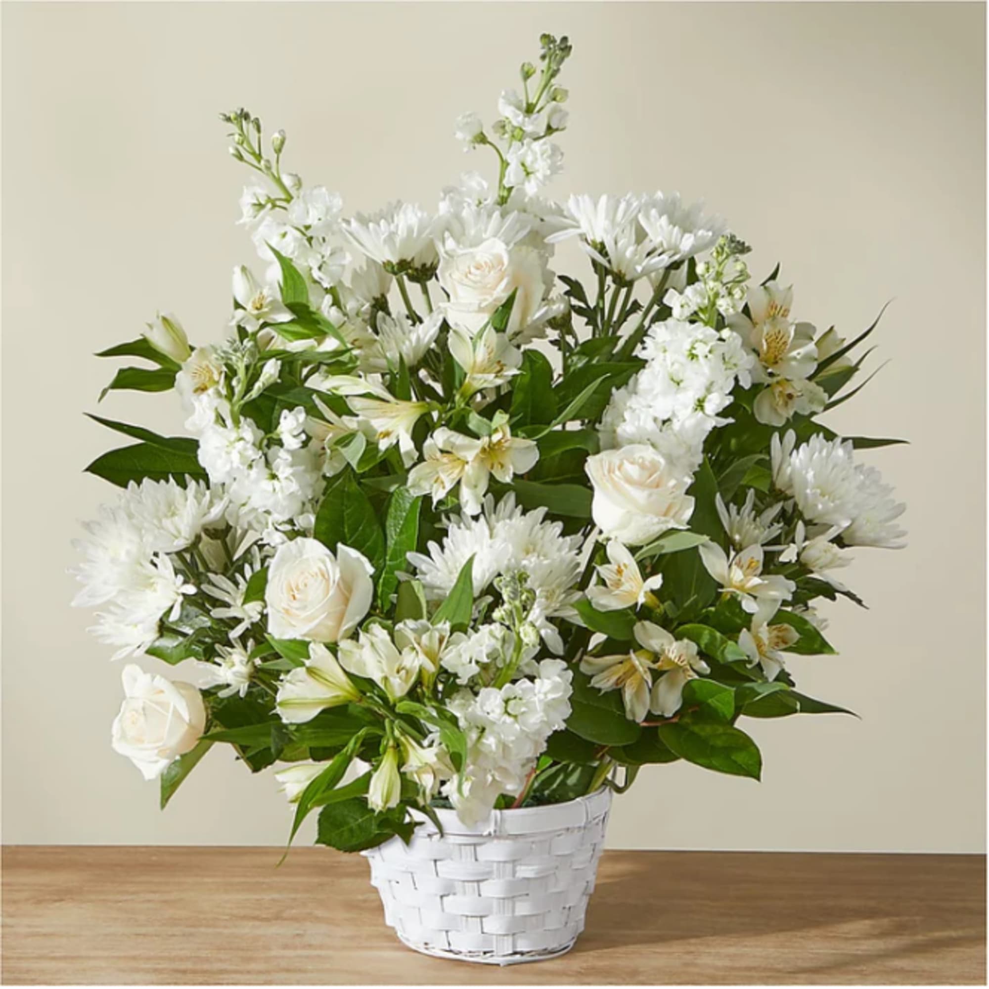 White floral arrangement in a white woven basket