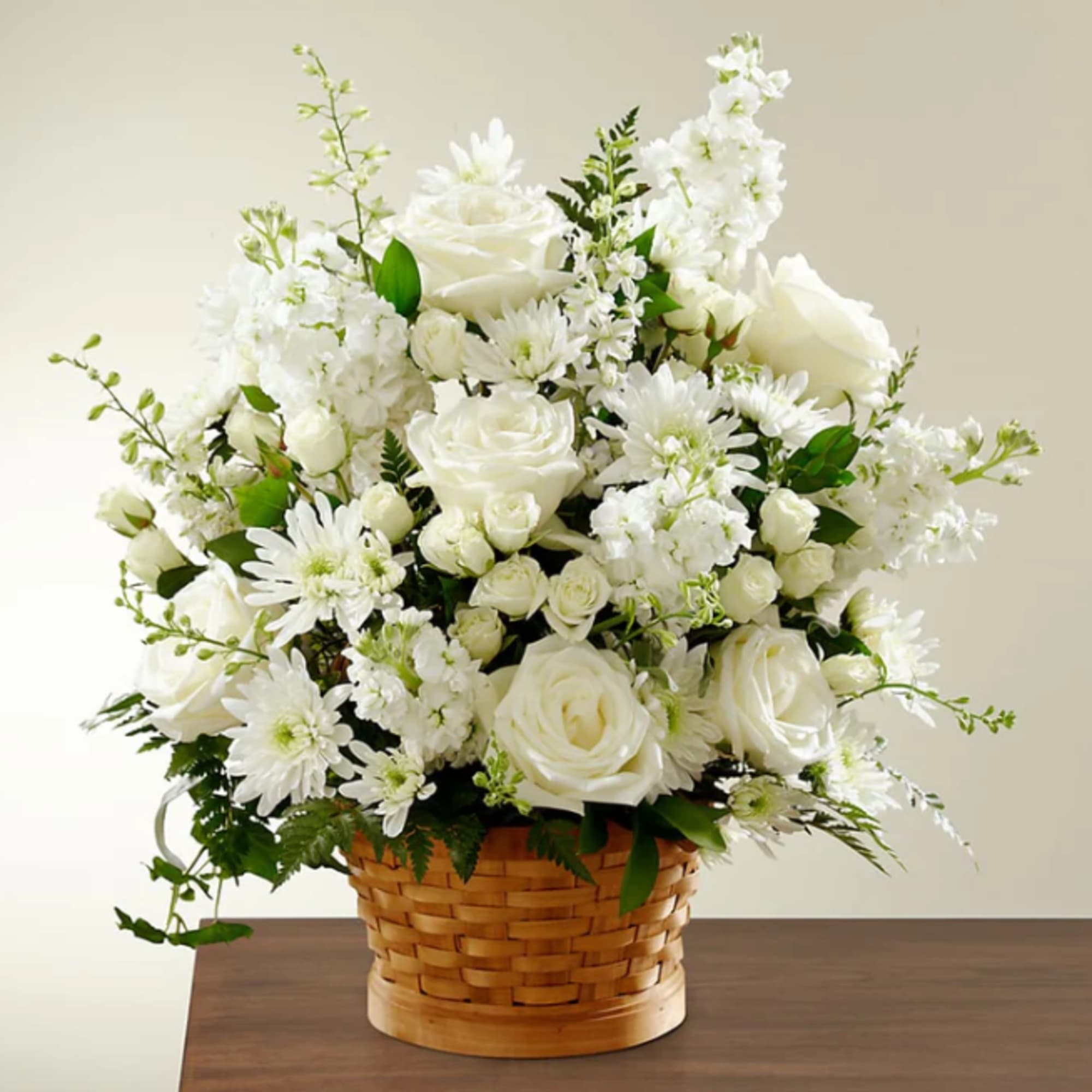 White roses and daisies arranged in a woven basket