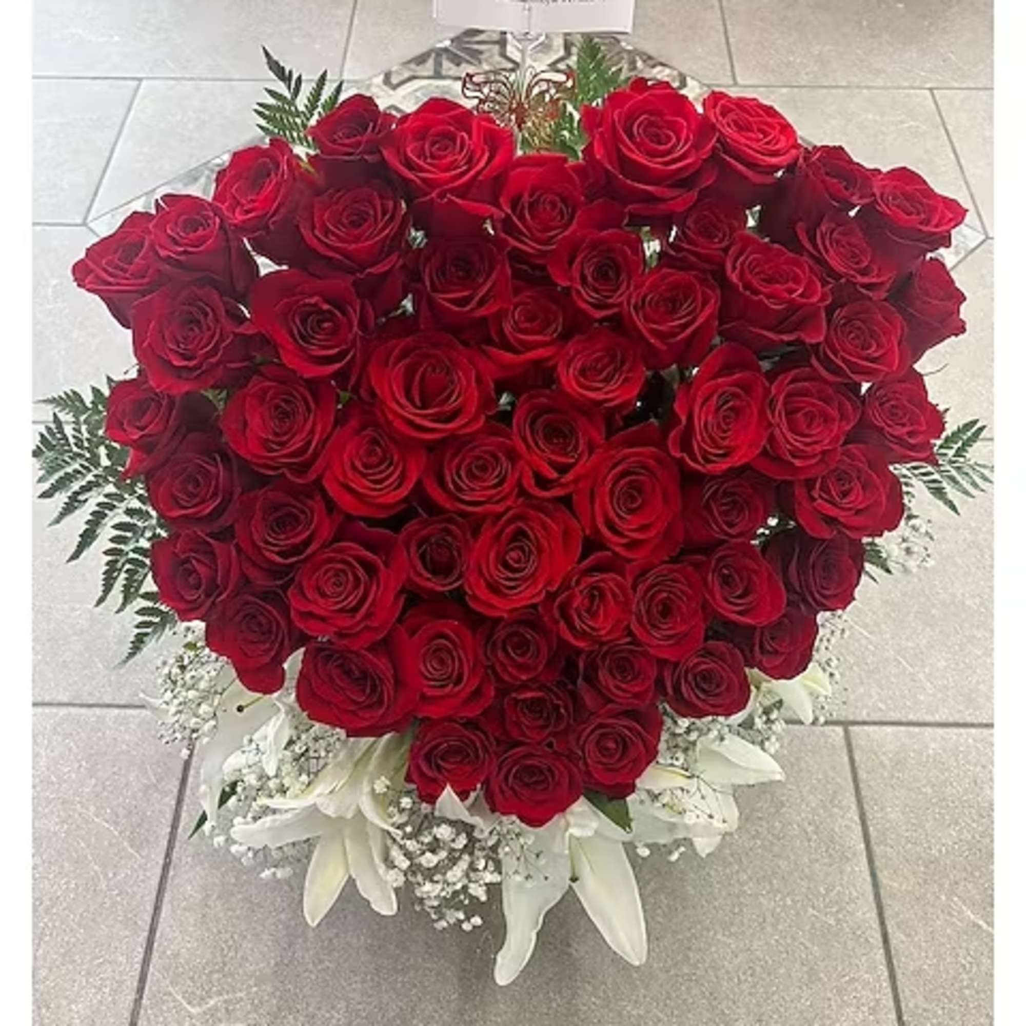 Large heart-shaped bouquet of red roses with white lilies
