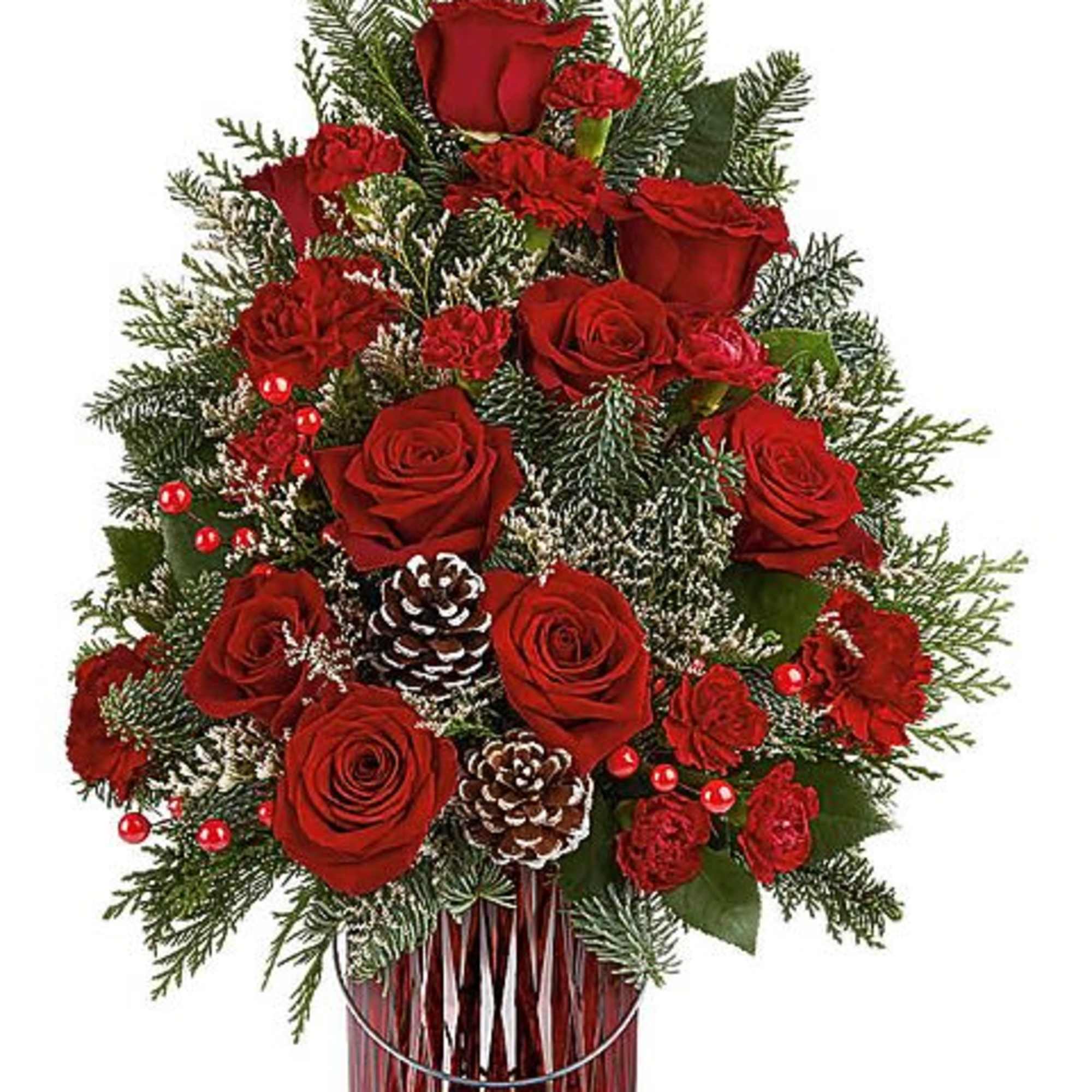 Red roses and carnations arranged in a glass vase with pinecones and evergreen branches