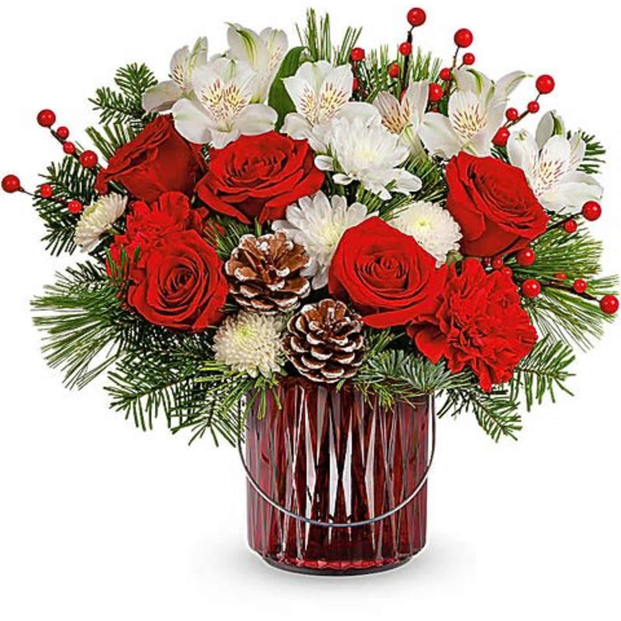 Red roses and white flowers arranged in a red glass vase with pinecones