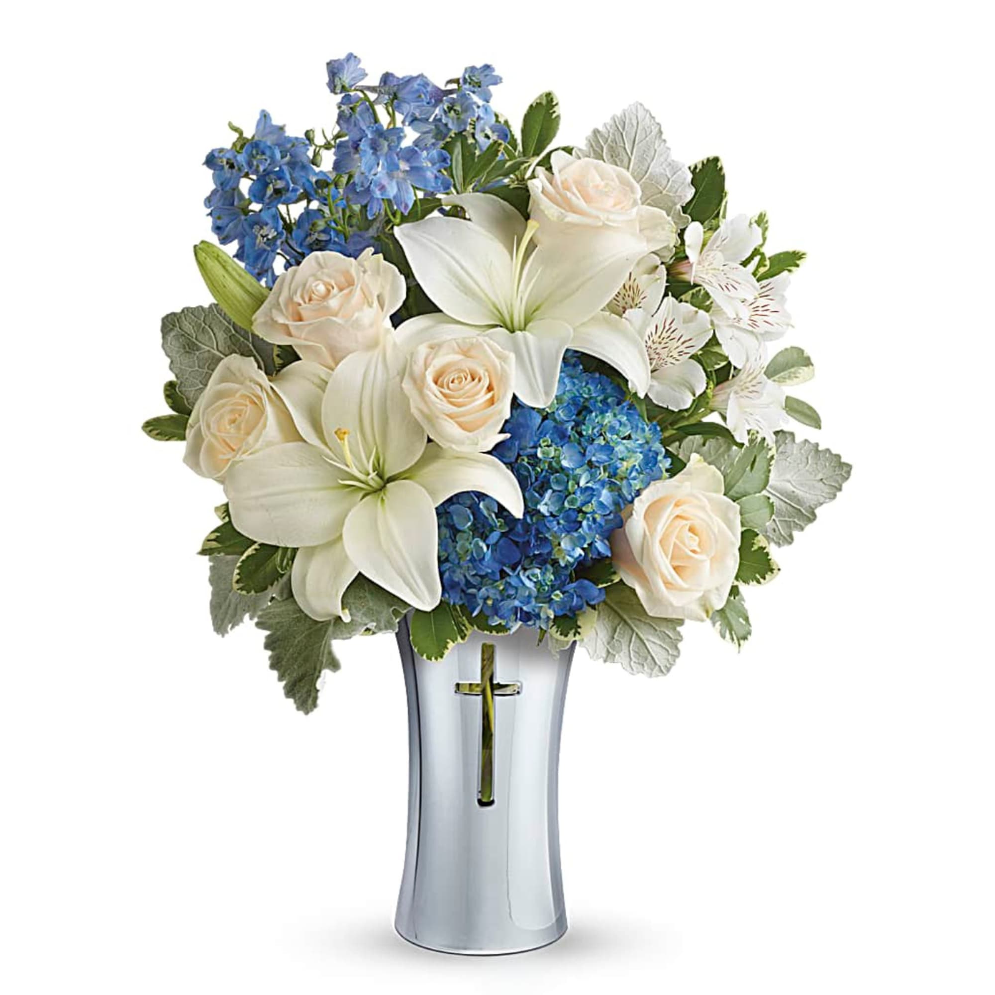 White lilies, cream roses, and blue hydrangeas in a silver vase with a cross