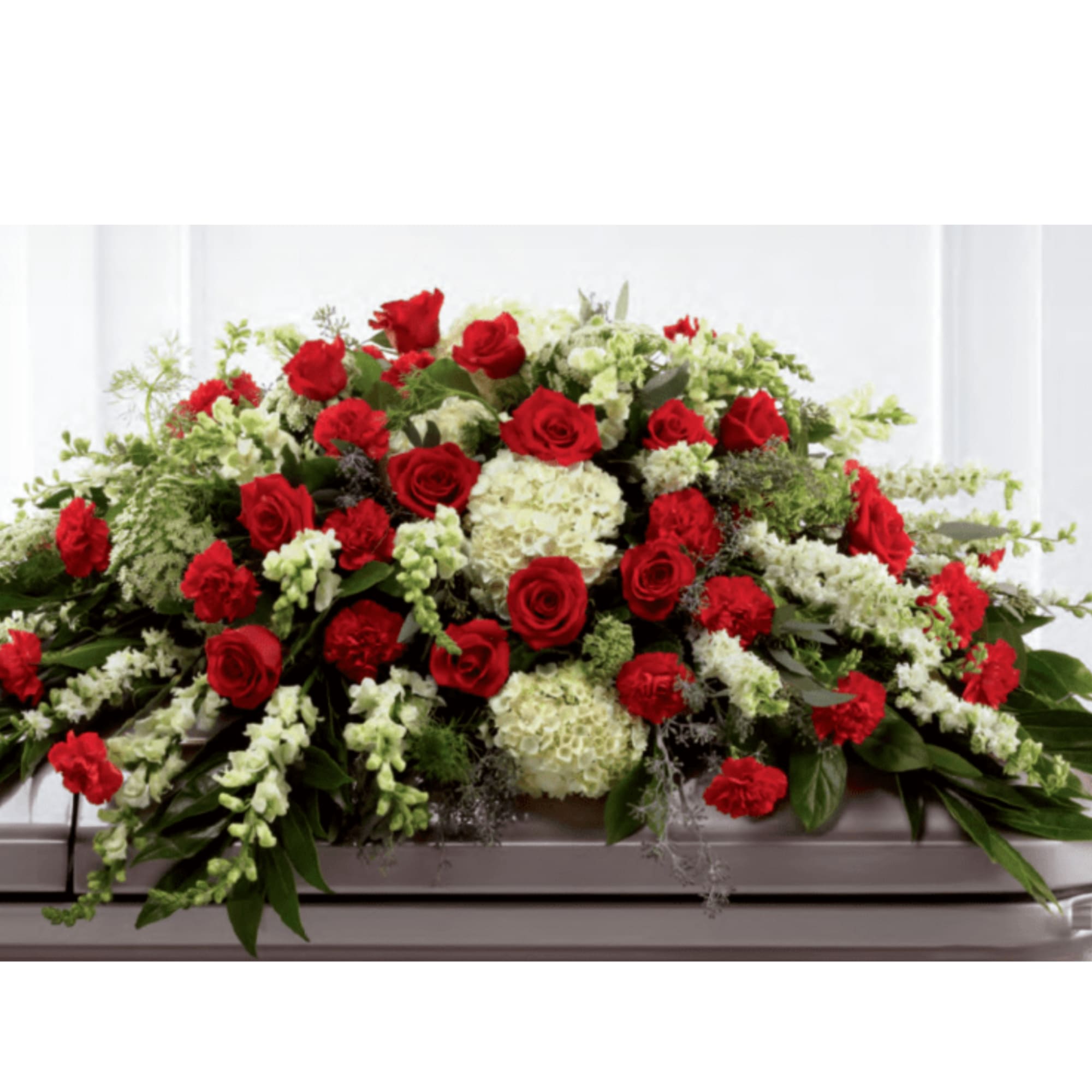 Red roses and white flowers arranged on a casket