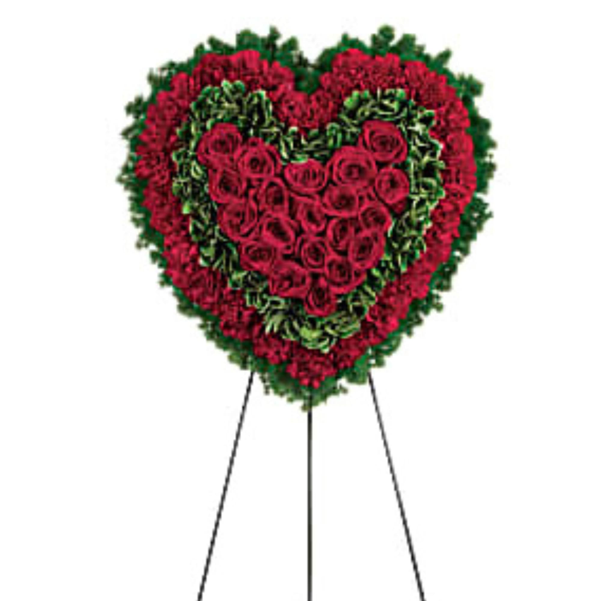 Heart-shaped standing floral wreath of red roses and greenery on an easel
