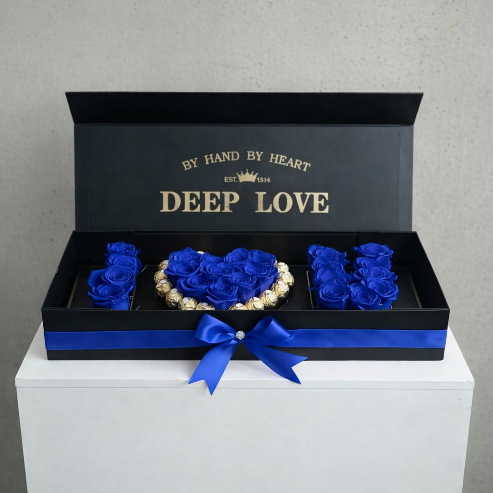 Blue roses arranged in a black gift box with a ribbon bow