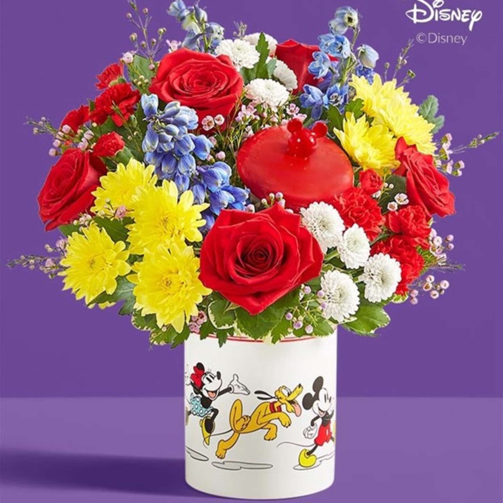 Bouquet of red roses, yellow chrysanthemums, and blue flowers in a Disney mug