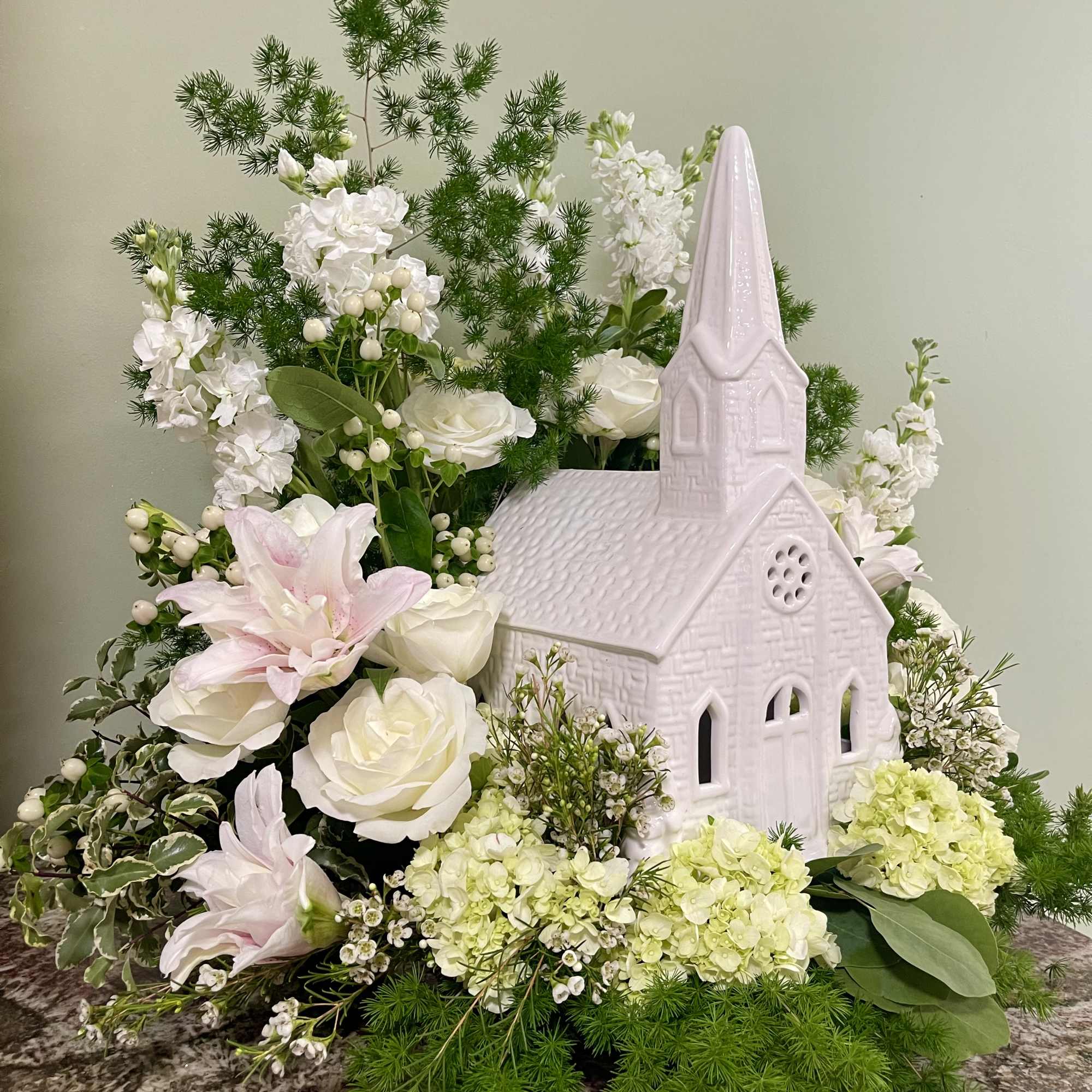 White floral arrangement with a pink church centerpiece