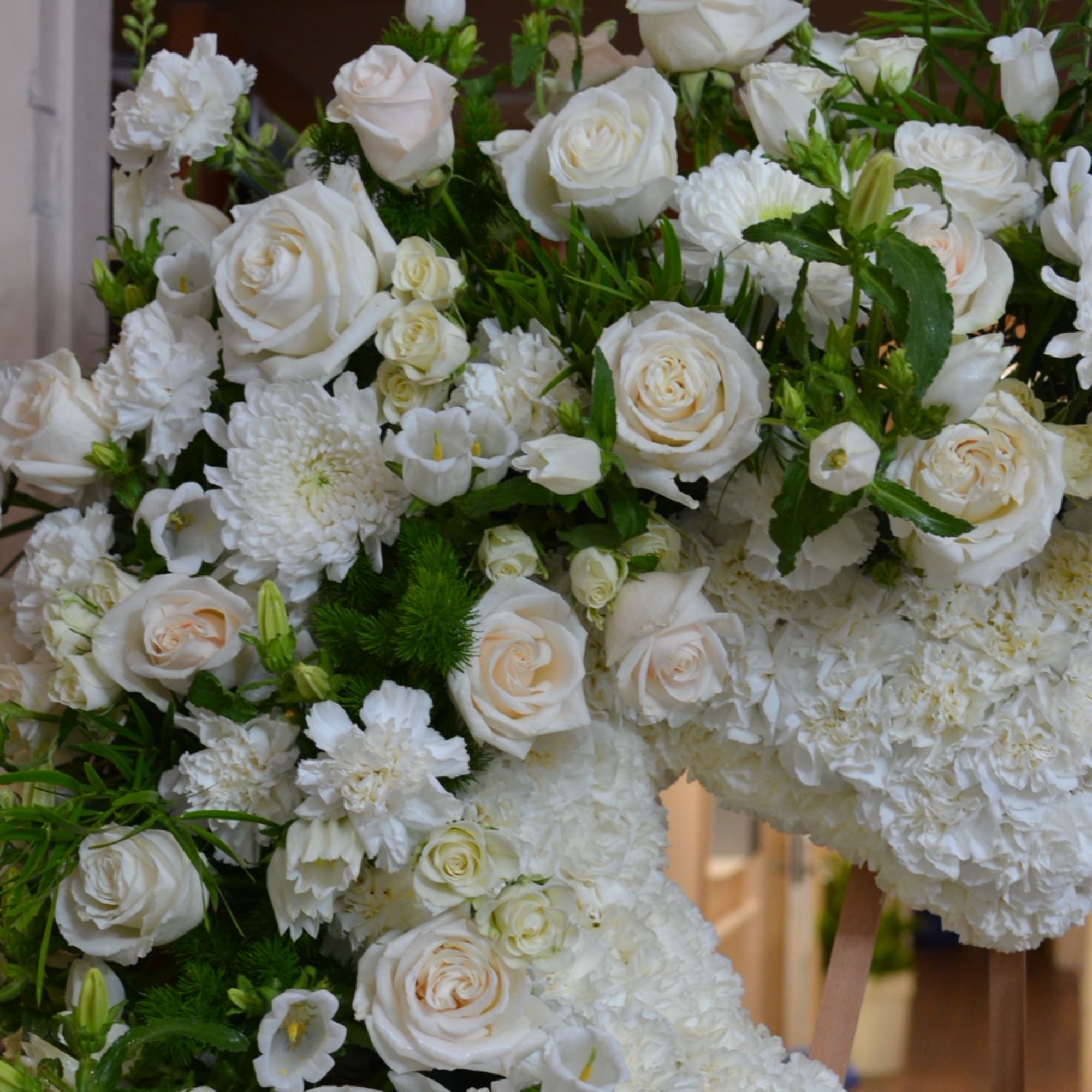 White roses and chrysanthemums arranged in a large floral wreath