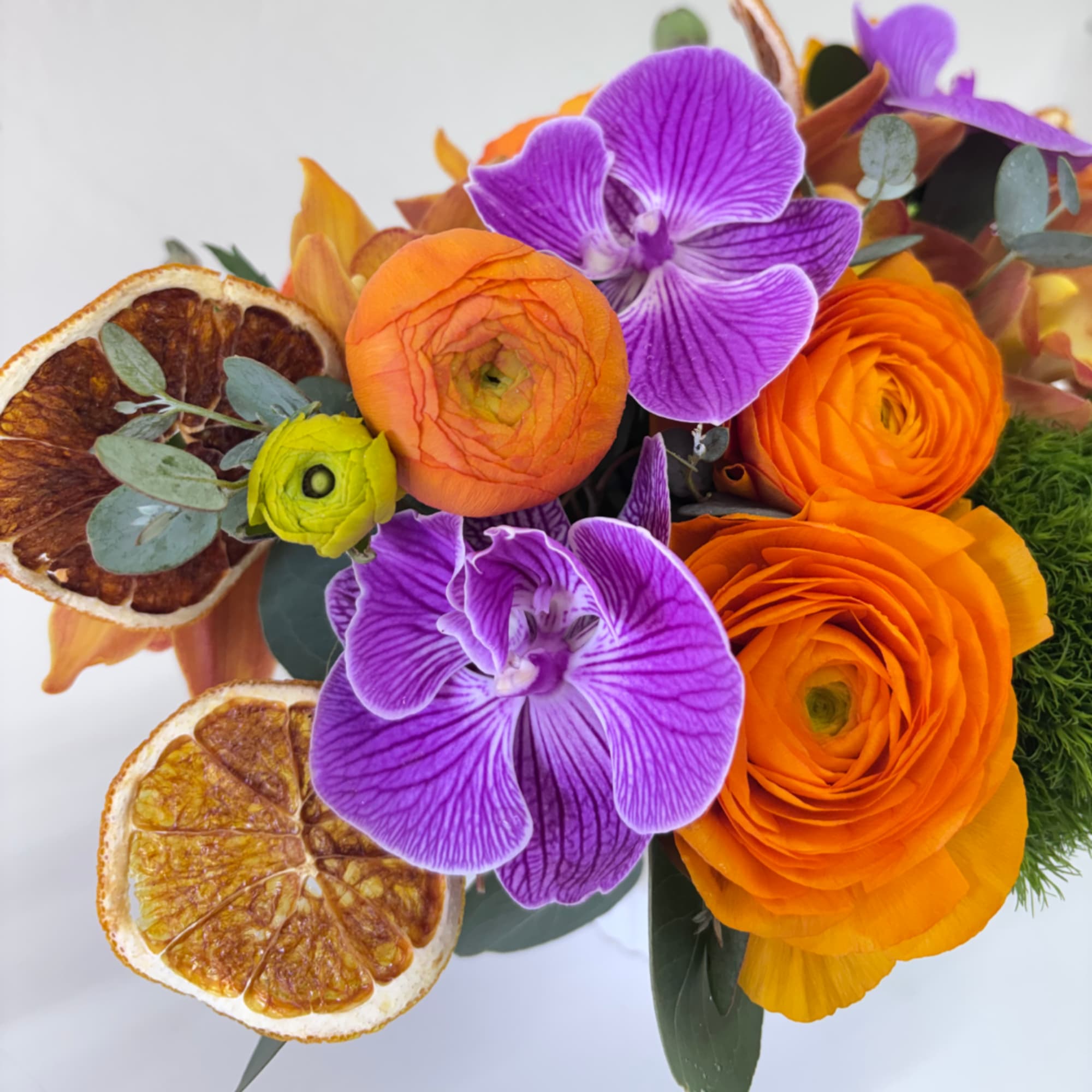 Orange and purple floral bouquet with dried citrus slices