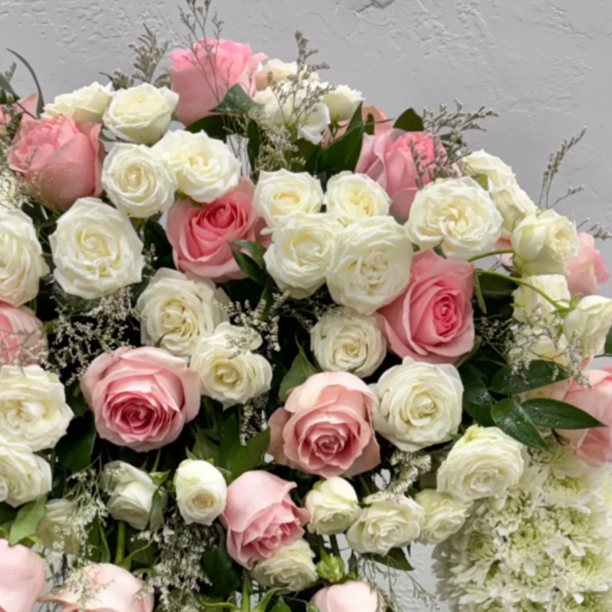 Bouquet of pink and white roses with small filler flowers