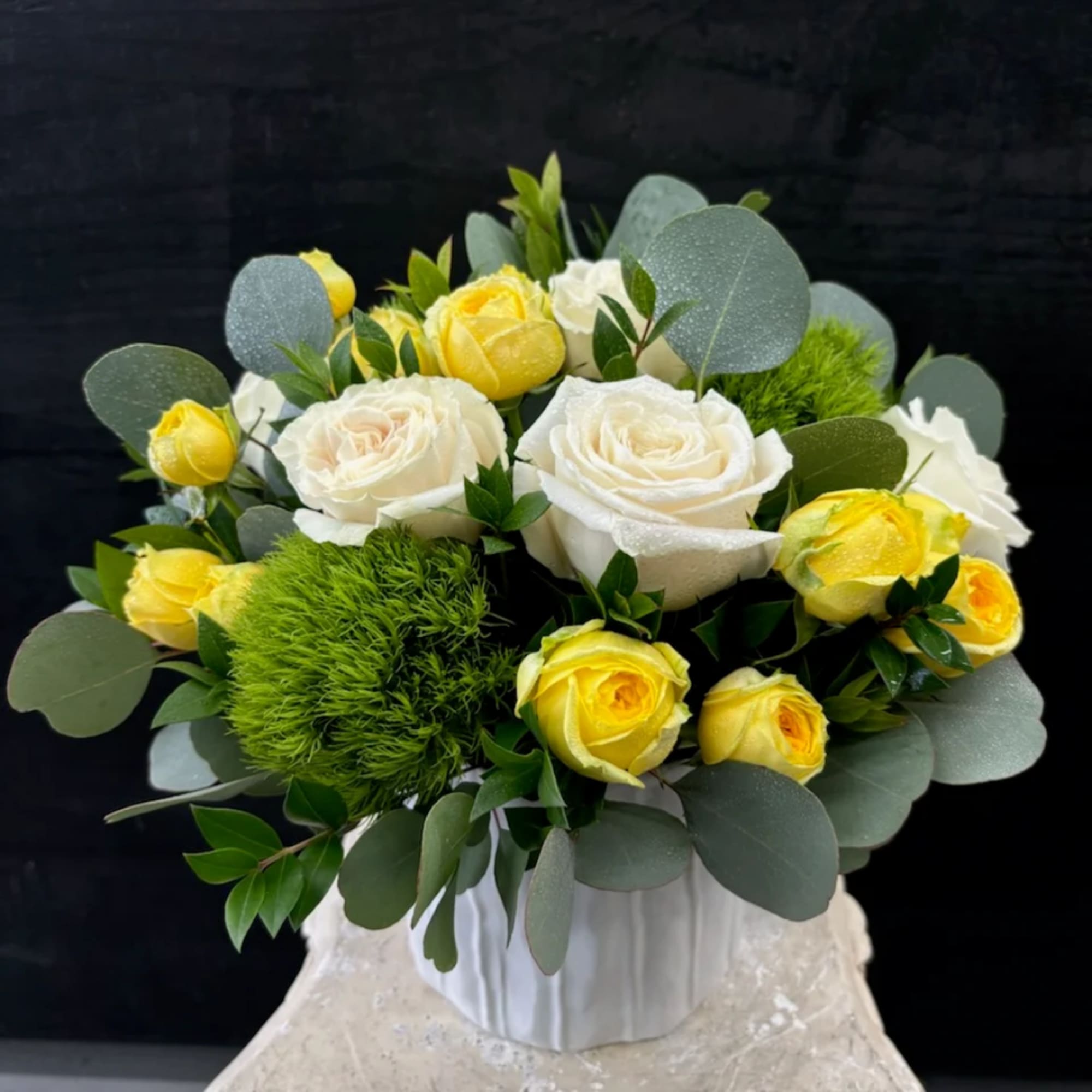 Bouquet of white and yellow roses in a white vase