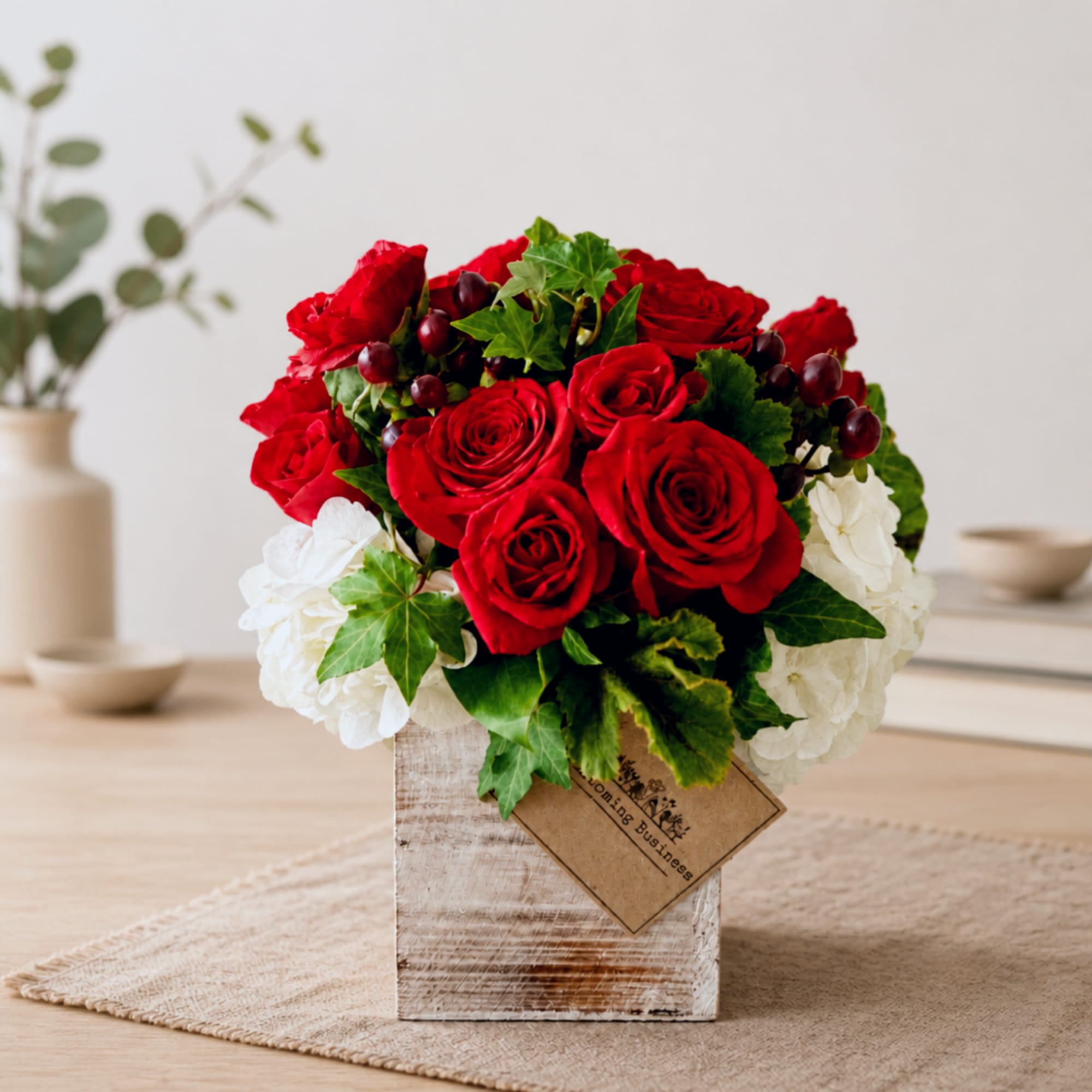 Red roses and white hydrangeas arranged in a rustic wooden box