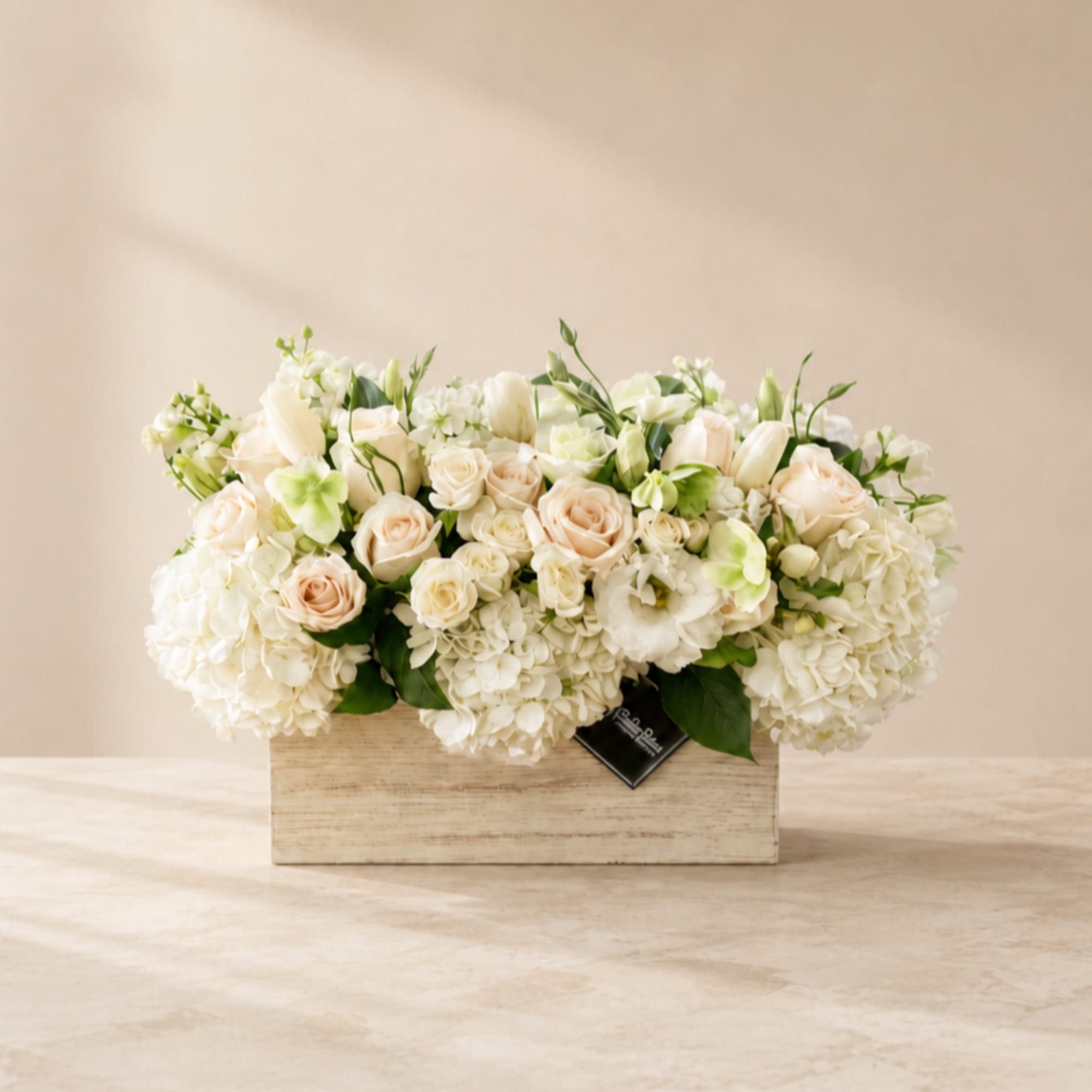 Cream and white flowers arranged in a rectangular wooden box