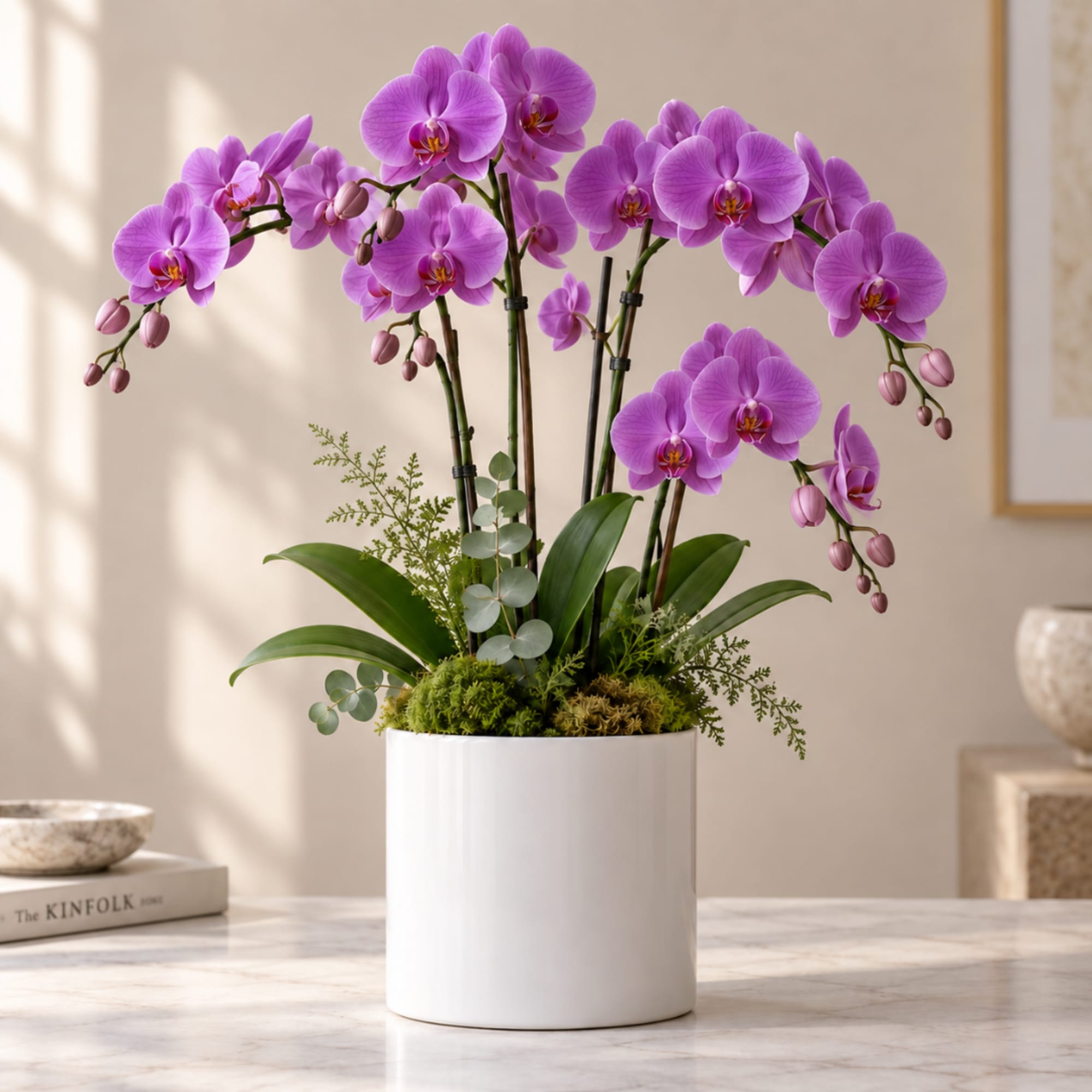 Purple orchids arranged in a white pot on a tabletop