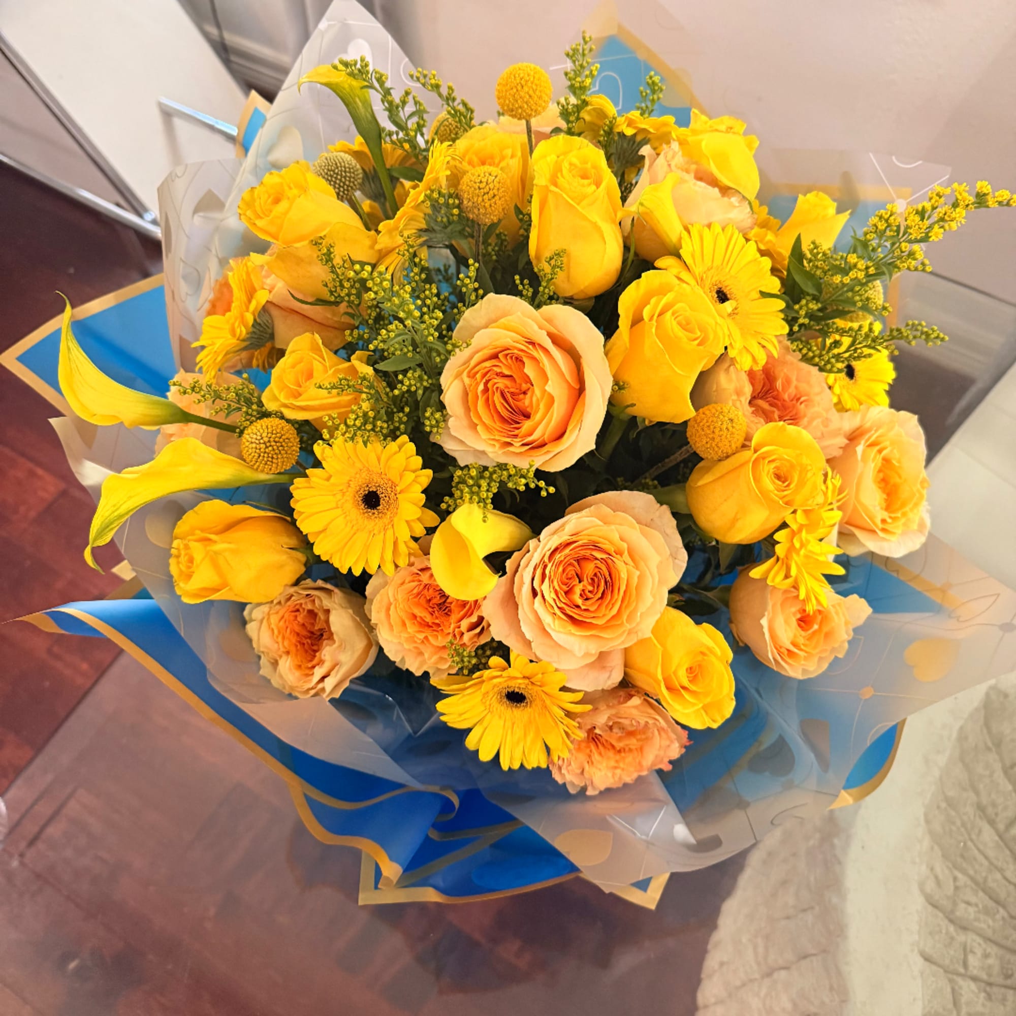 Bouquet of yellow and peach roses with yellow daisies and calla lilies
