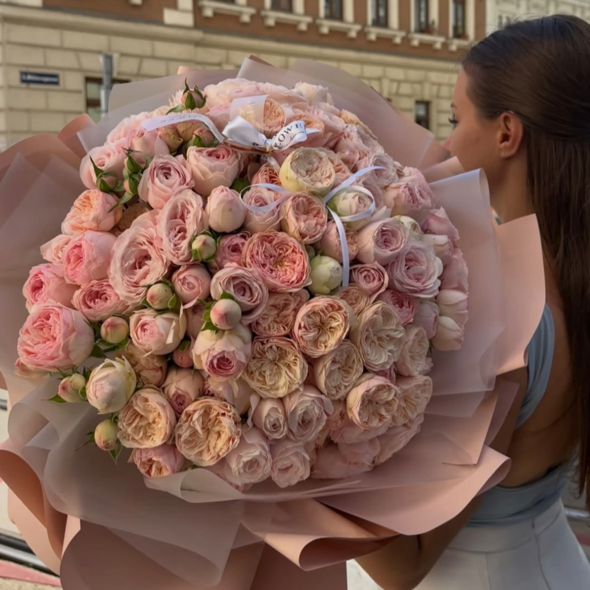 Large bouquet of pale pink roses wrapped in blush paper