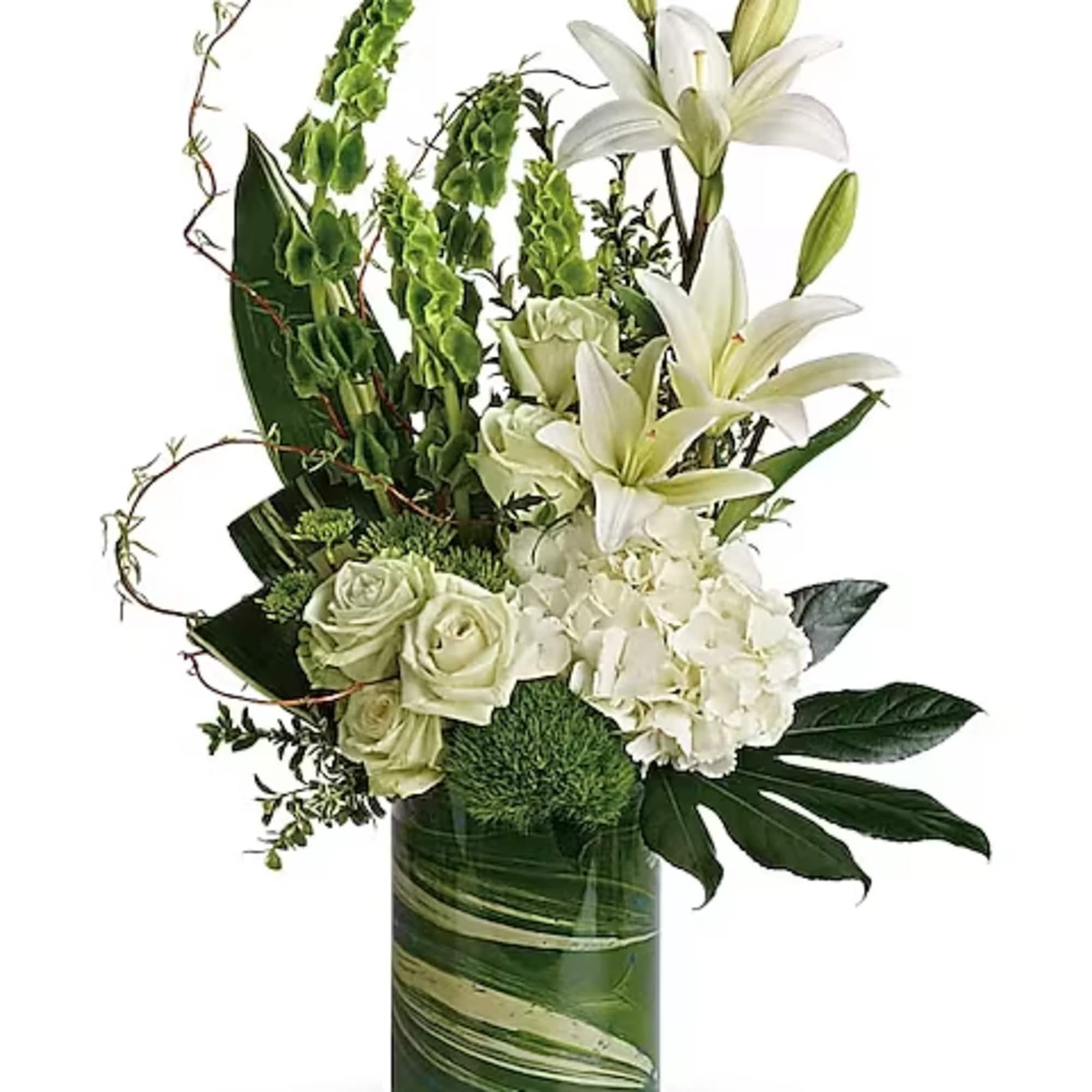White lilies, roses, and hydrangea in a green glass vase