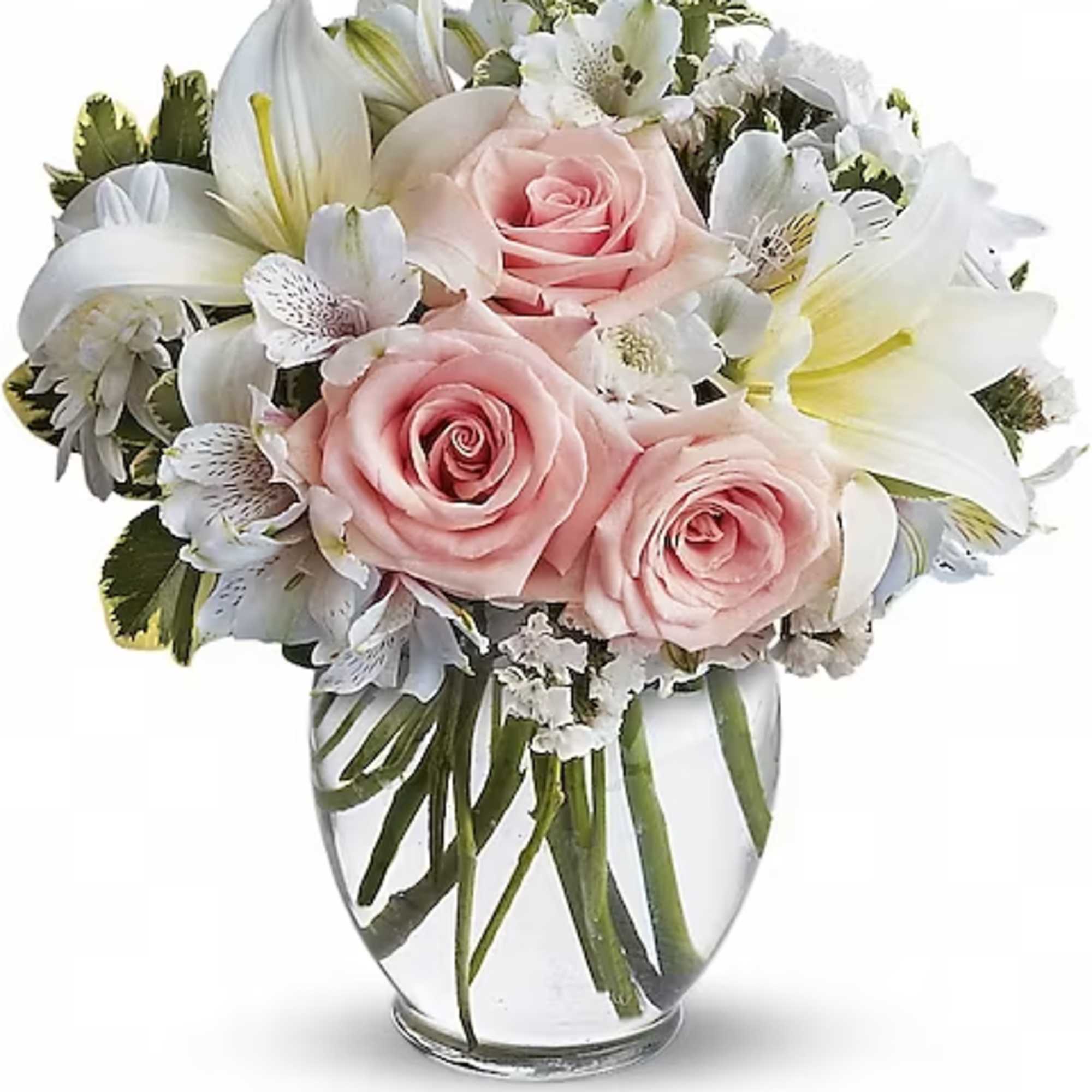 Pink roses and white lilies arranged in a clear glass vase