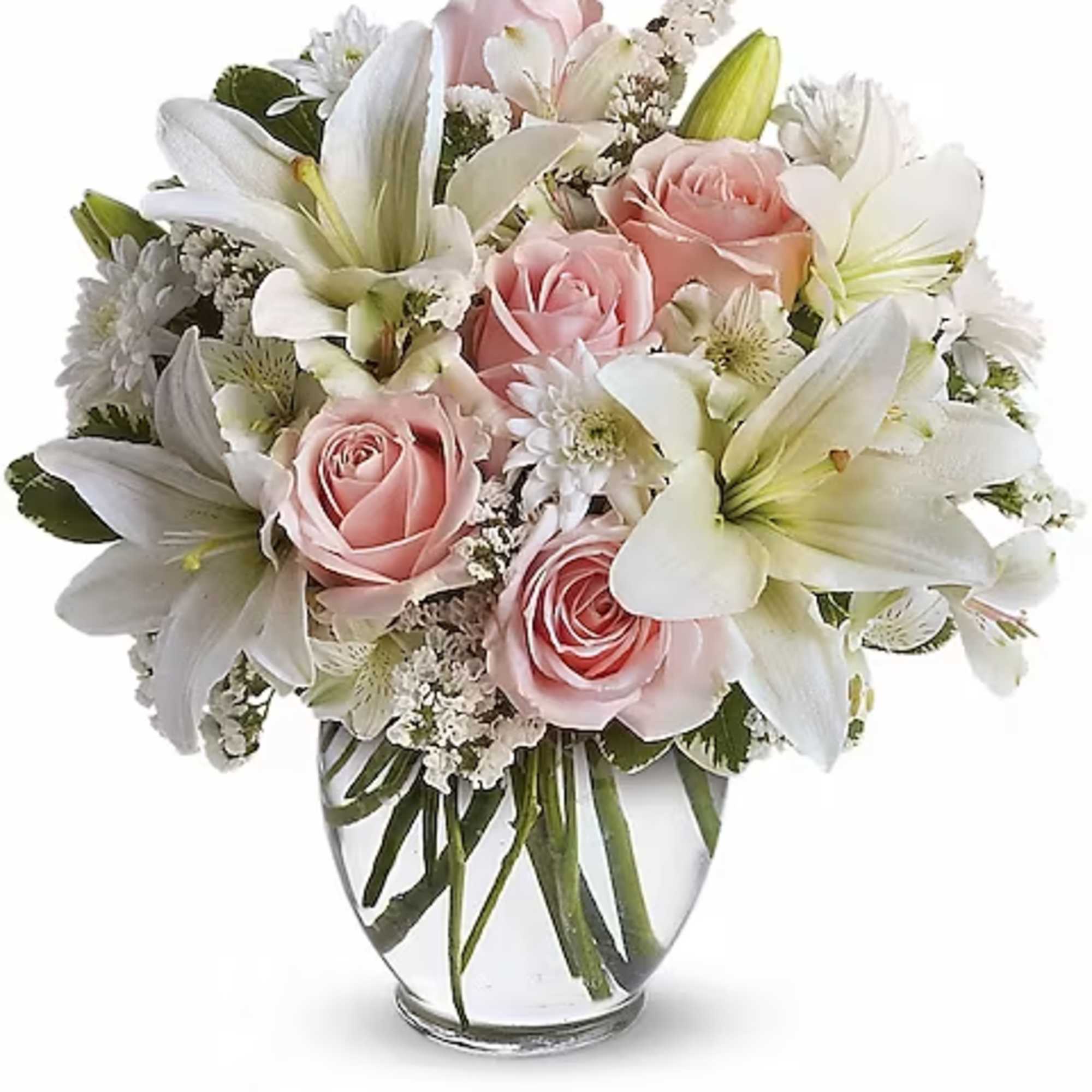 Pink roses and white lilies arranged in a clear glass vase