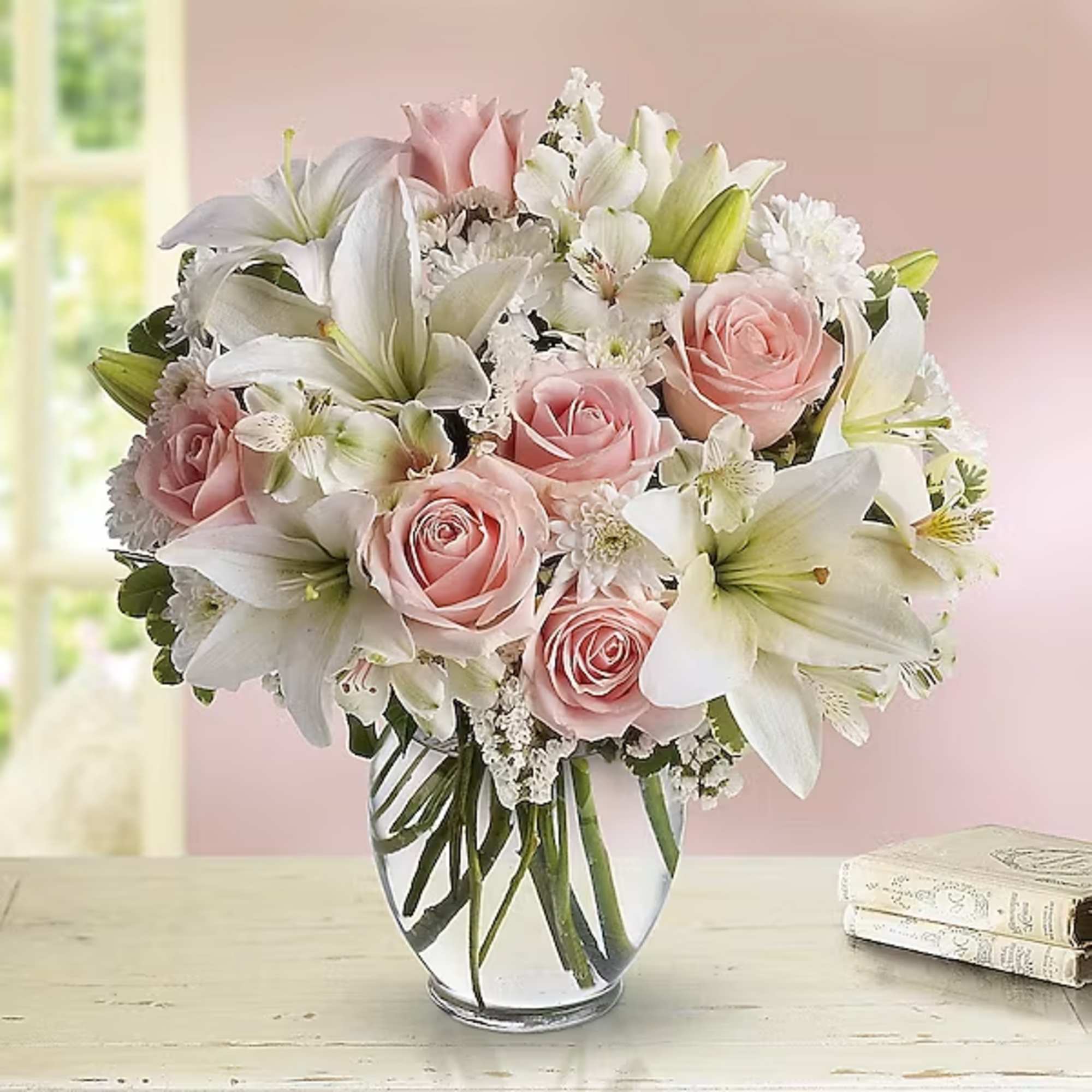 Pink roses and white lilies arranged in a clear glass vase, photo 2 of 2