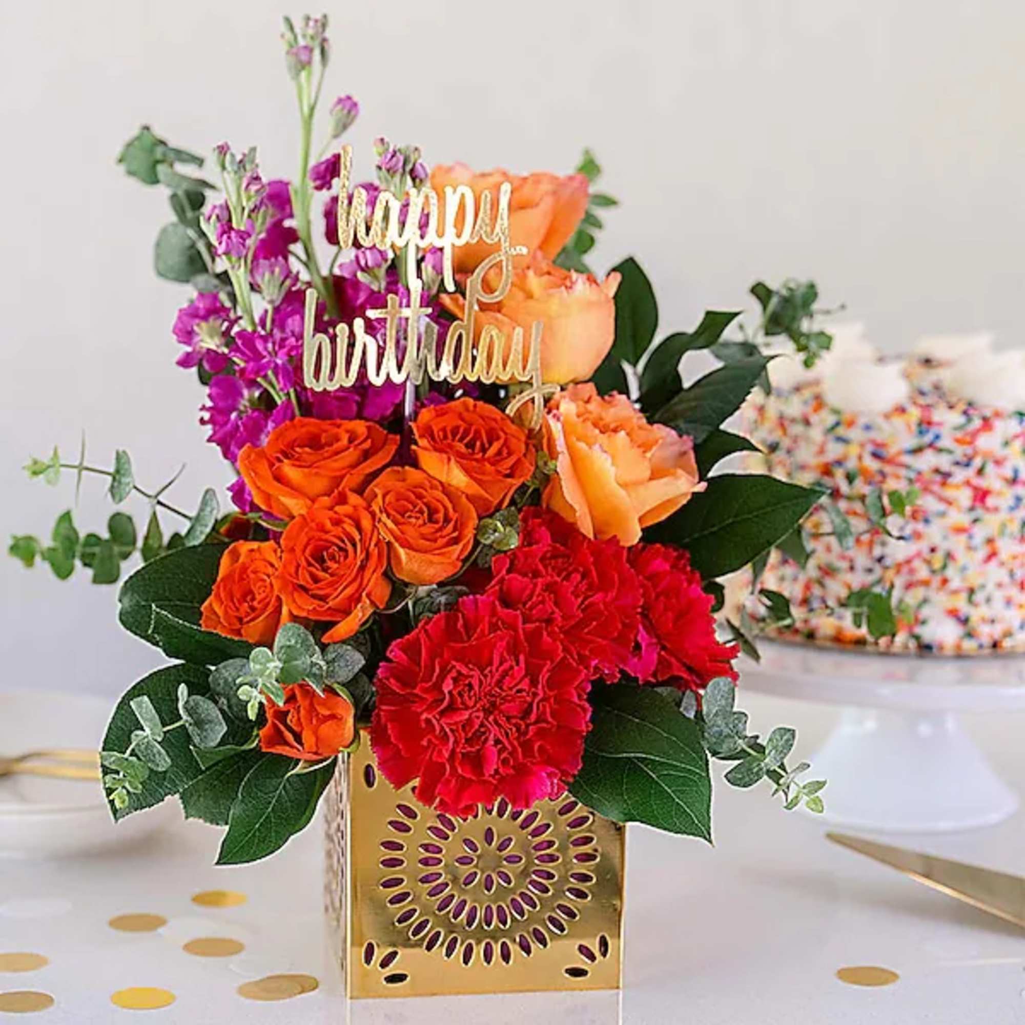 Birthday flower arrangement with roses, carnations, and a gold topper