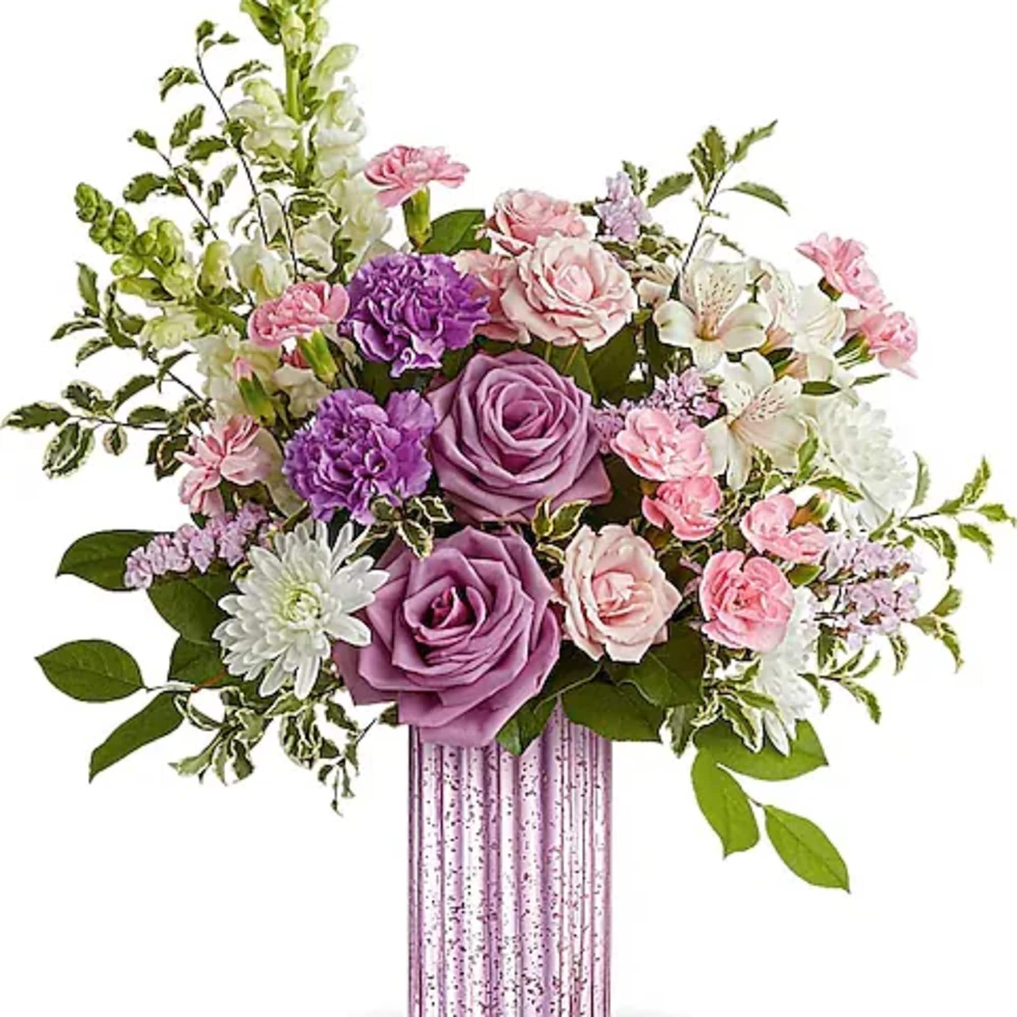 Pink and purple floral arrangement in a ribbed glass vase