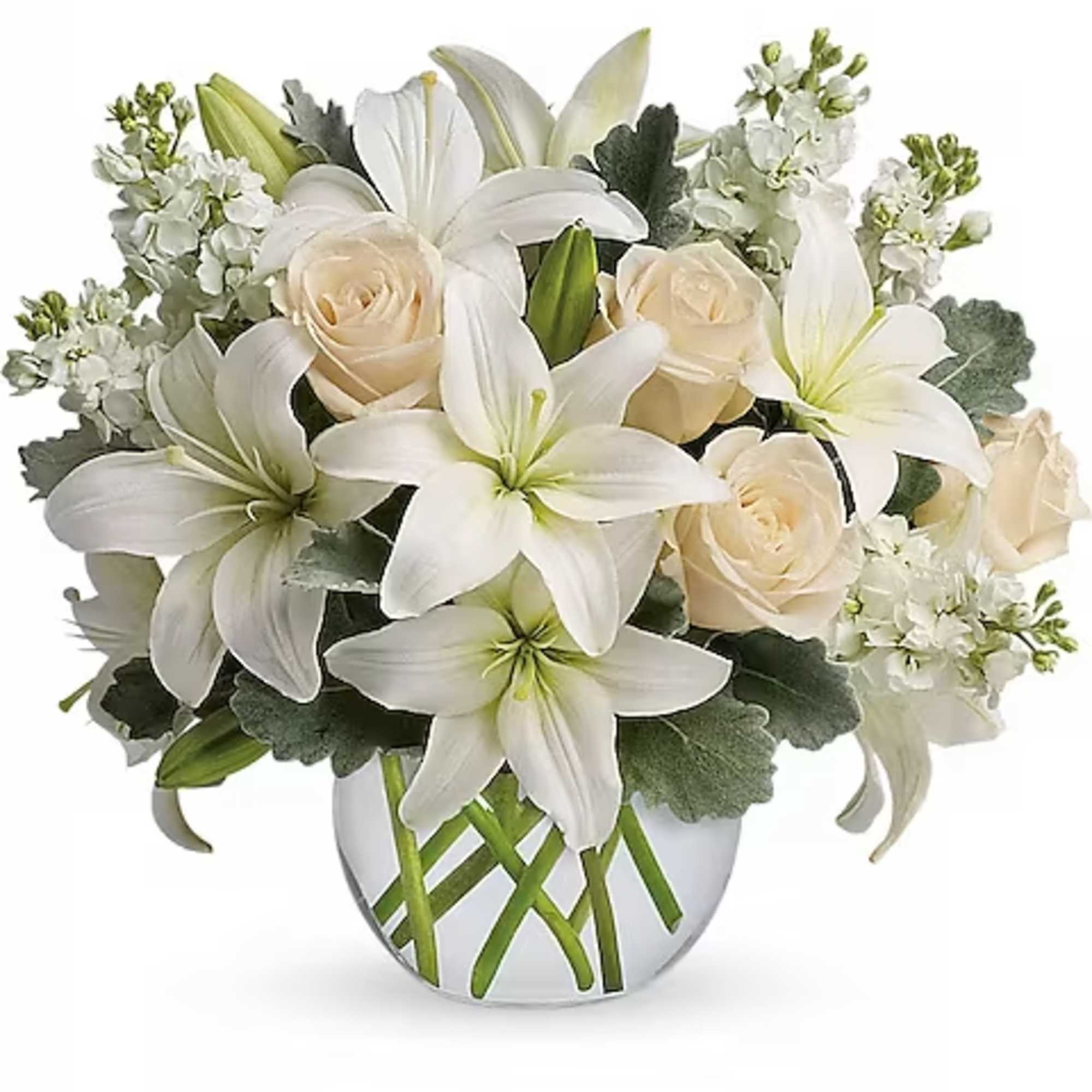 White lilies and cream roses arranged in a clear vase