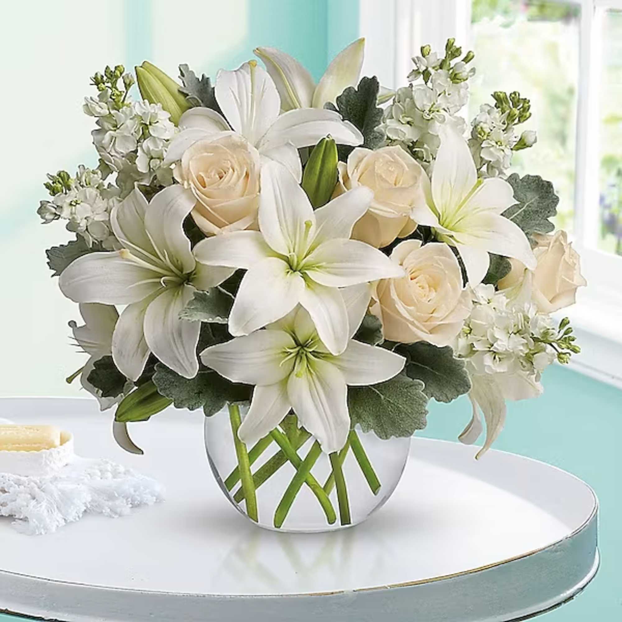 White lilies and cream roses in a glass vase