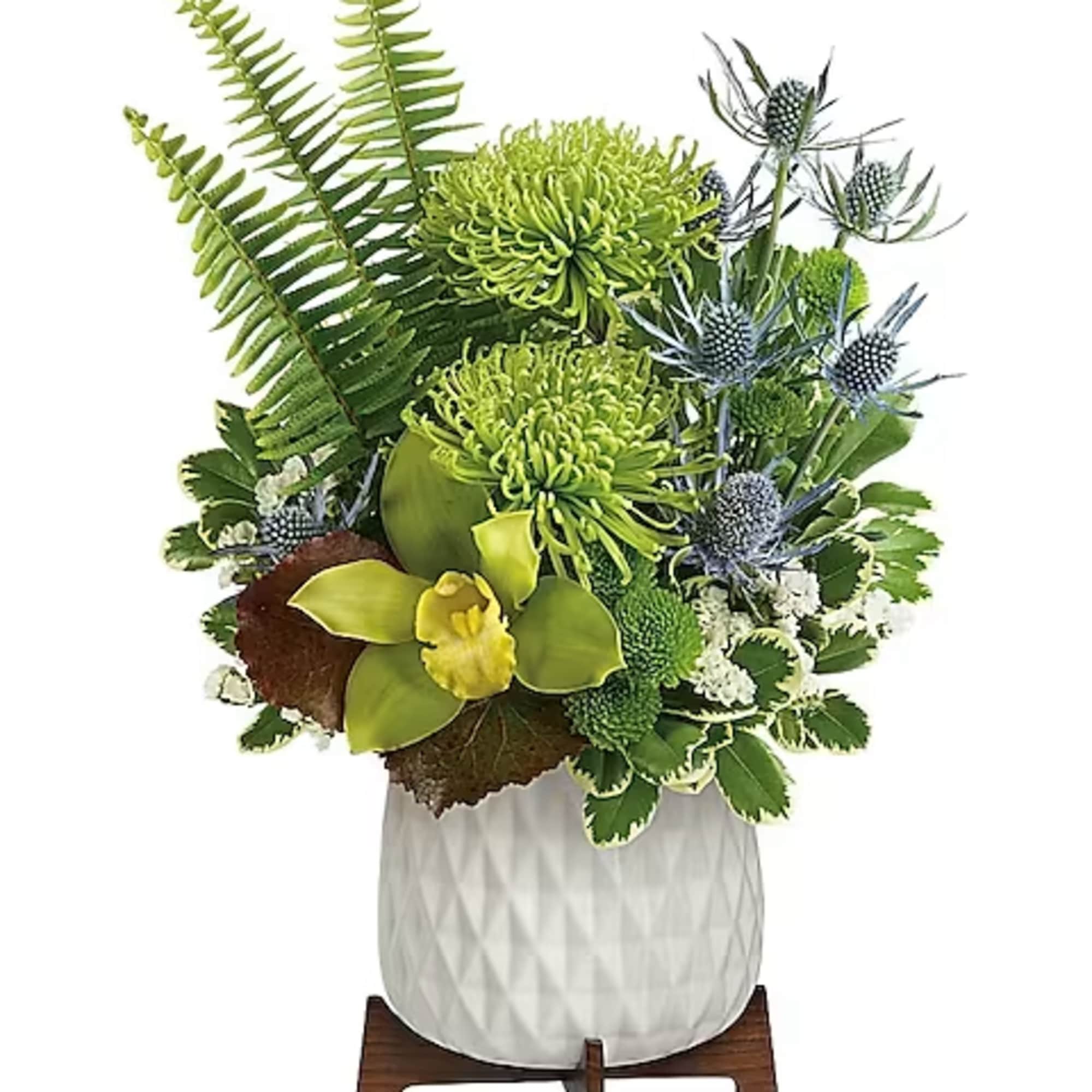 Green floral arrangement in a white textured vase on a wooden stand