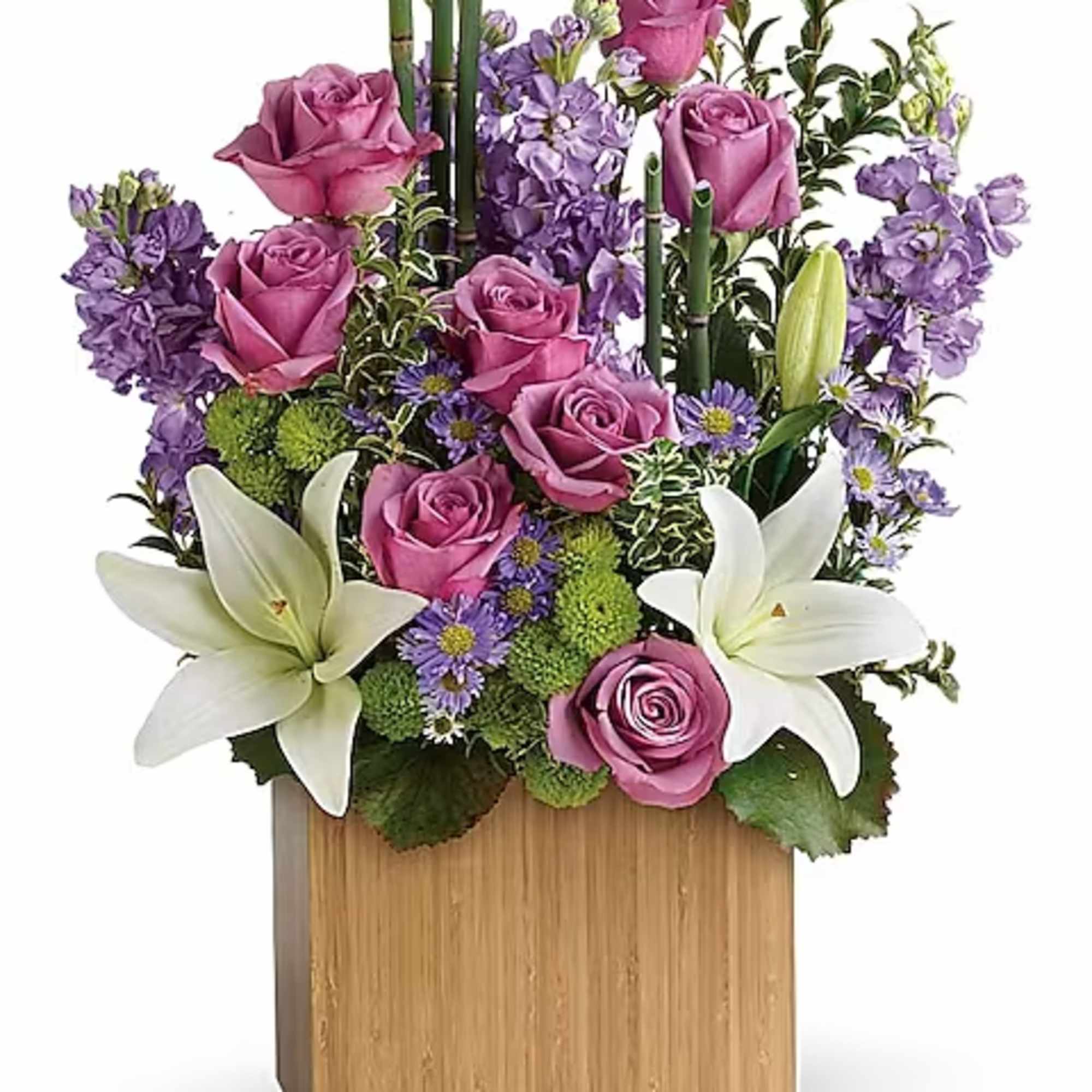 Pink roses and white lilies arranged in a wooden box with purple flowers