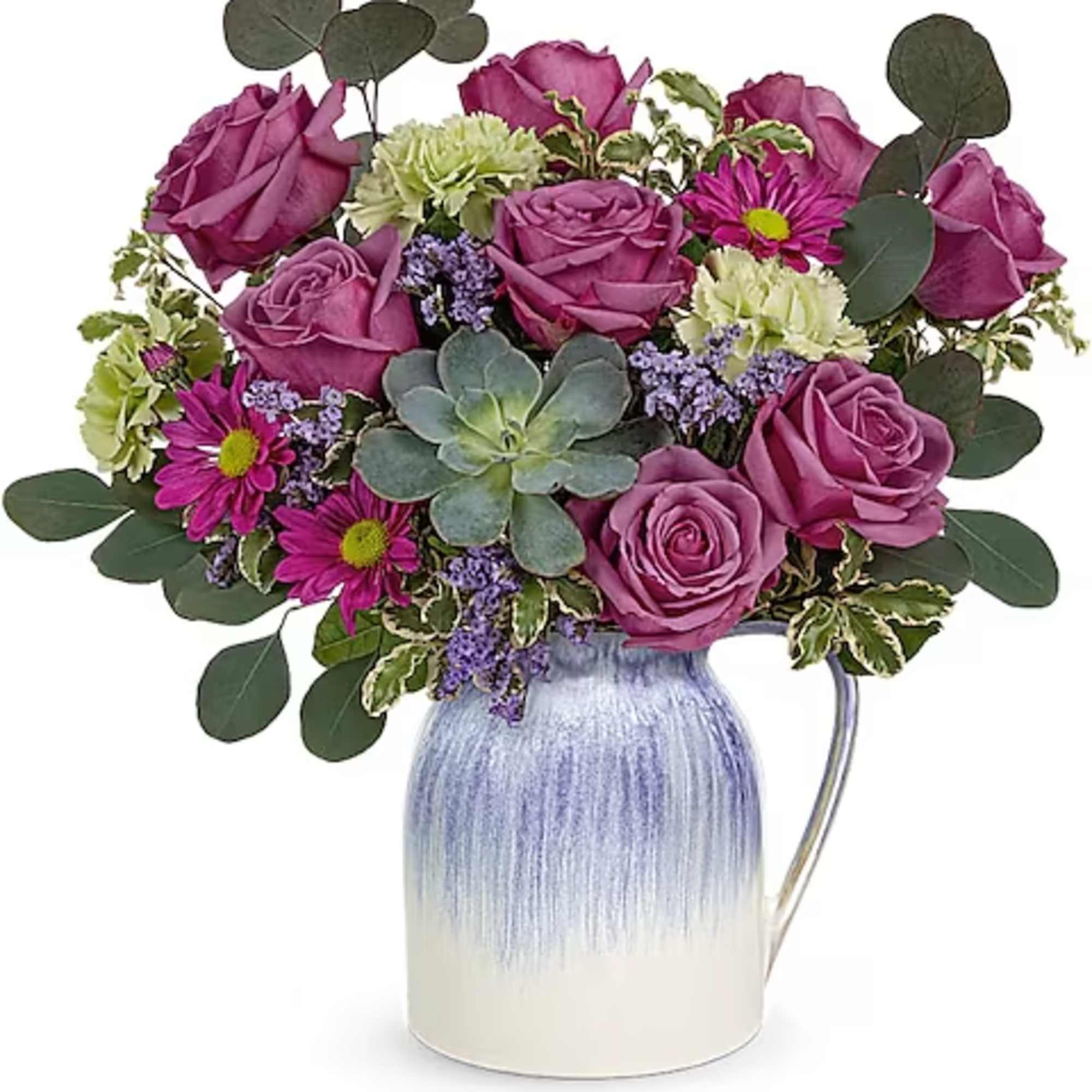 Purple roses and daisies arranged in a blue-and-white pitcher vase