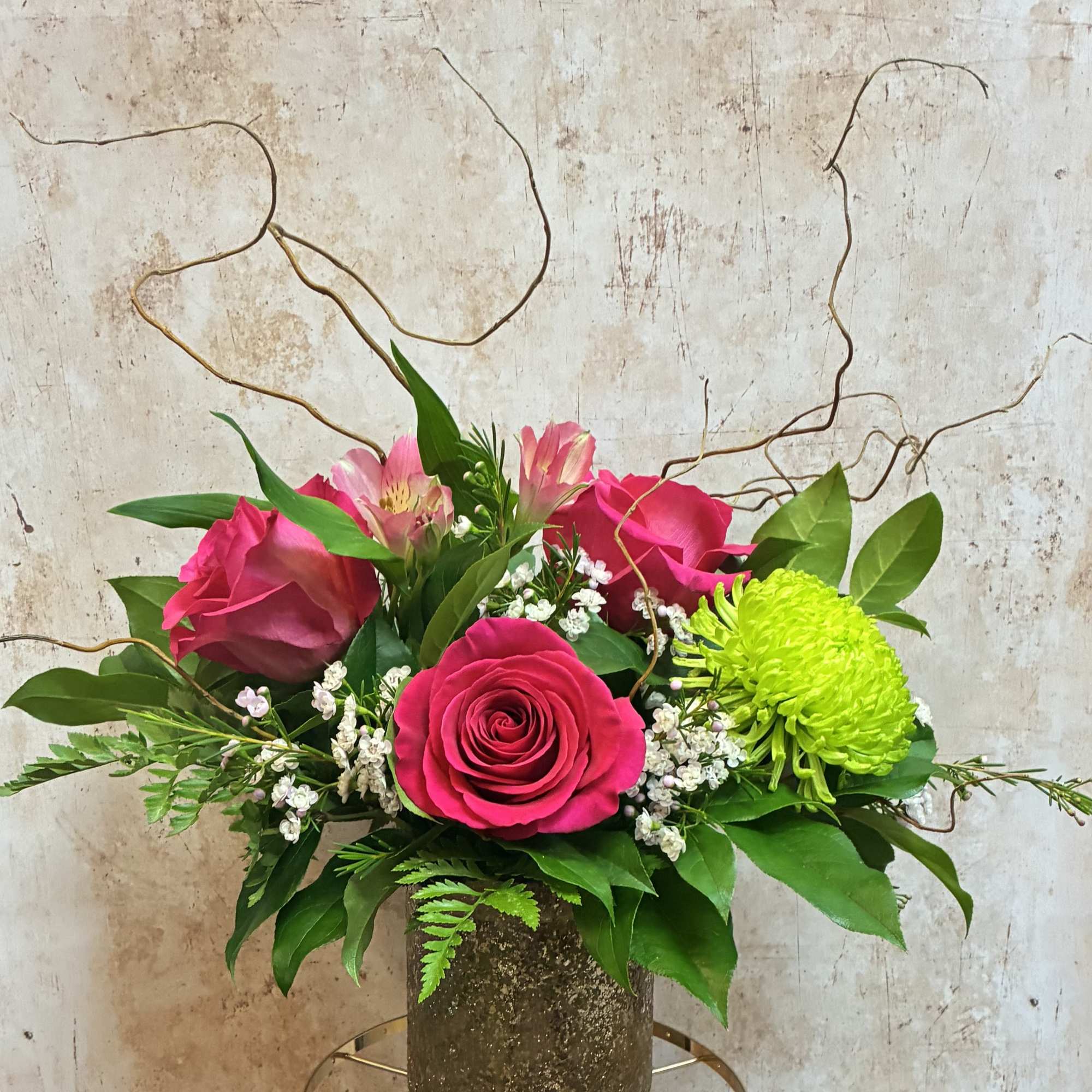 Pink roses and alstroemeria in a textured vase with bright green chrysanthemum