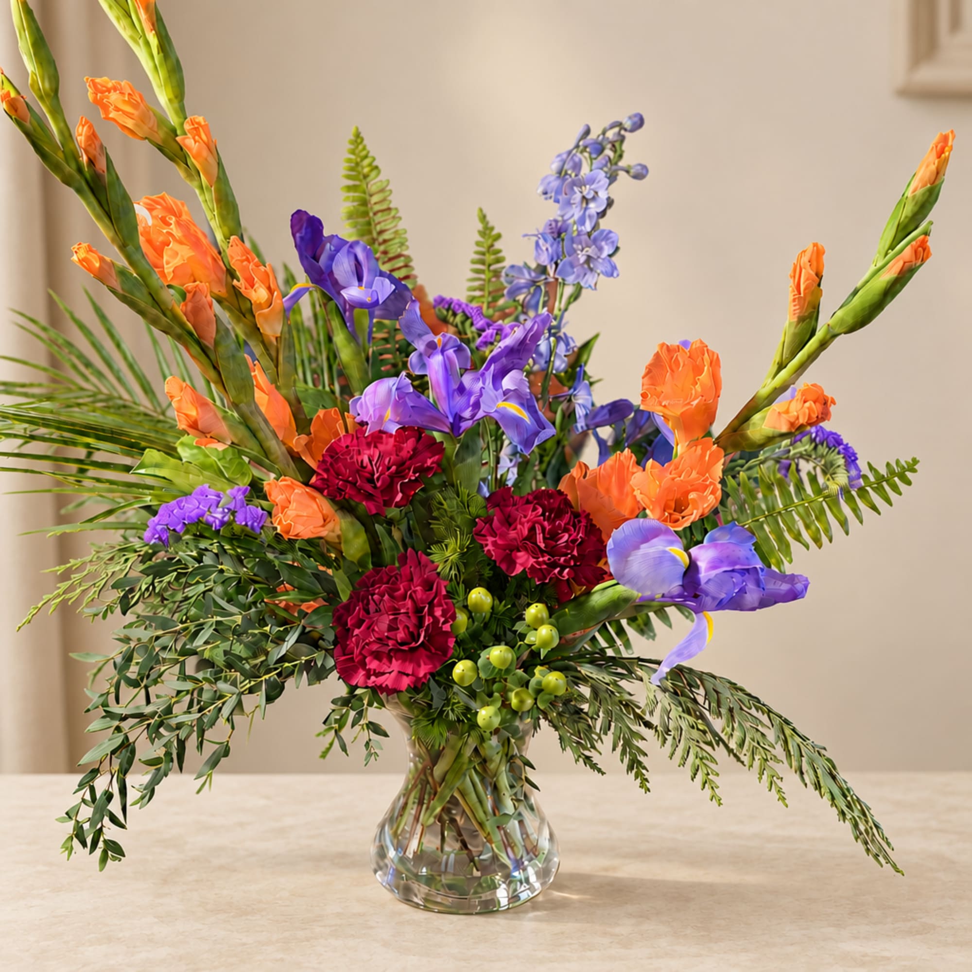 Colorful bouquet in a clear glass vase with orange, purple, and red flowers
