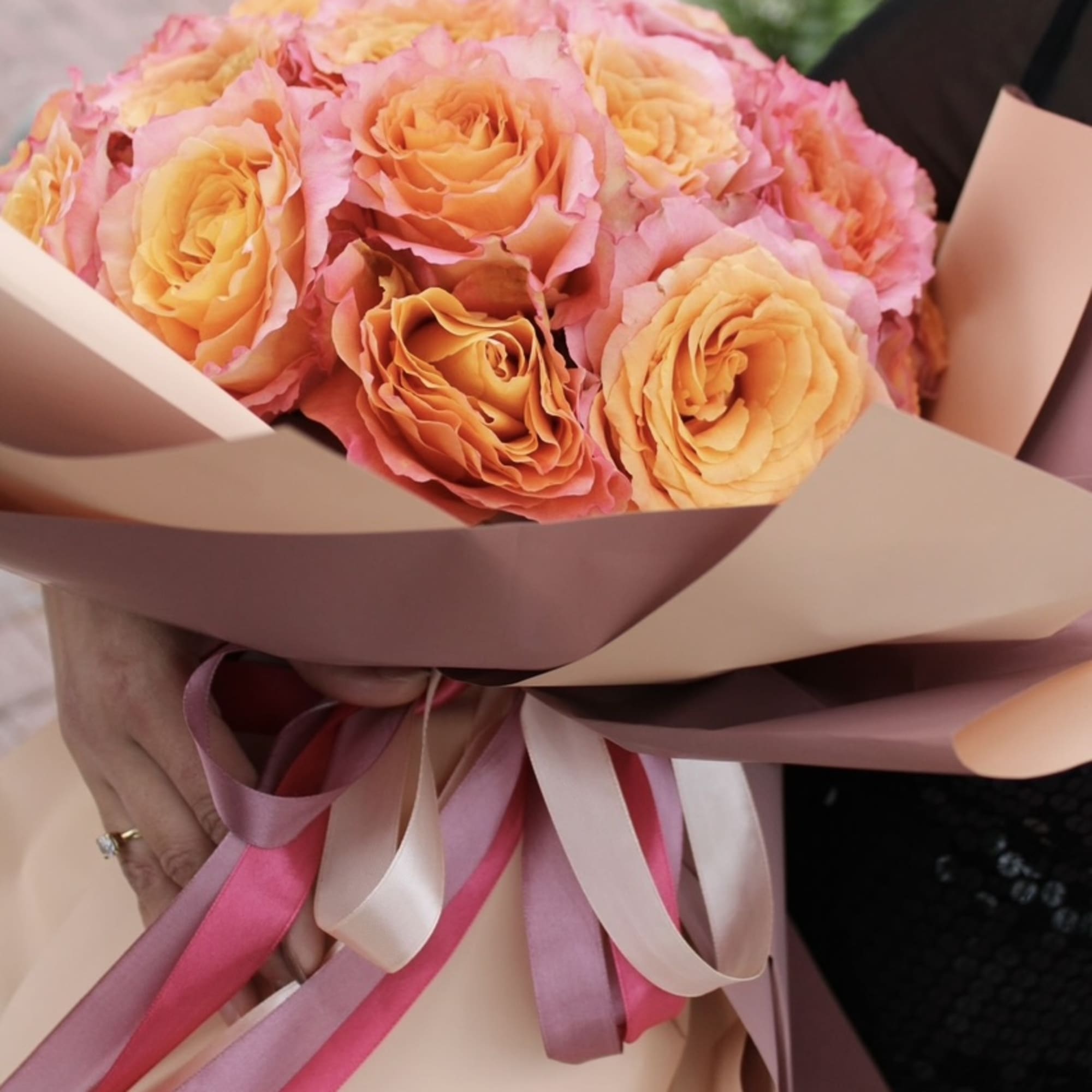Bouquet of peach and pink roses wrapped in blush paper with ribbons, photo 3 of 3
