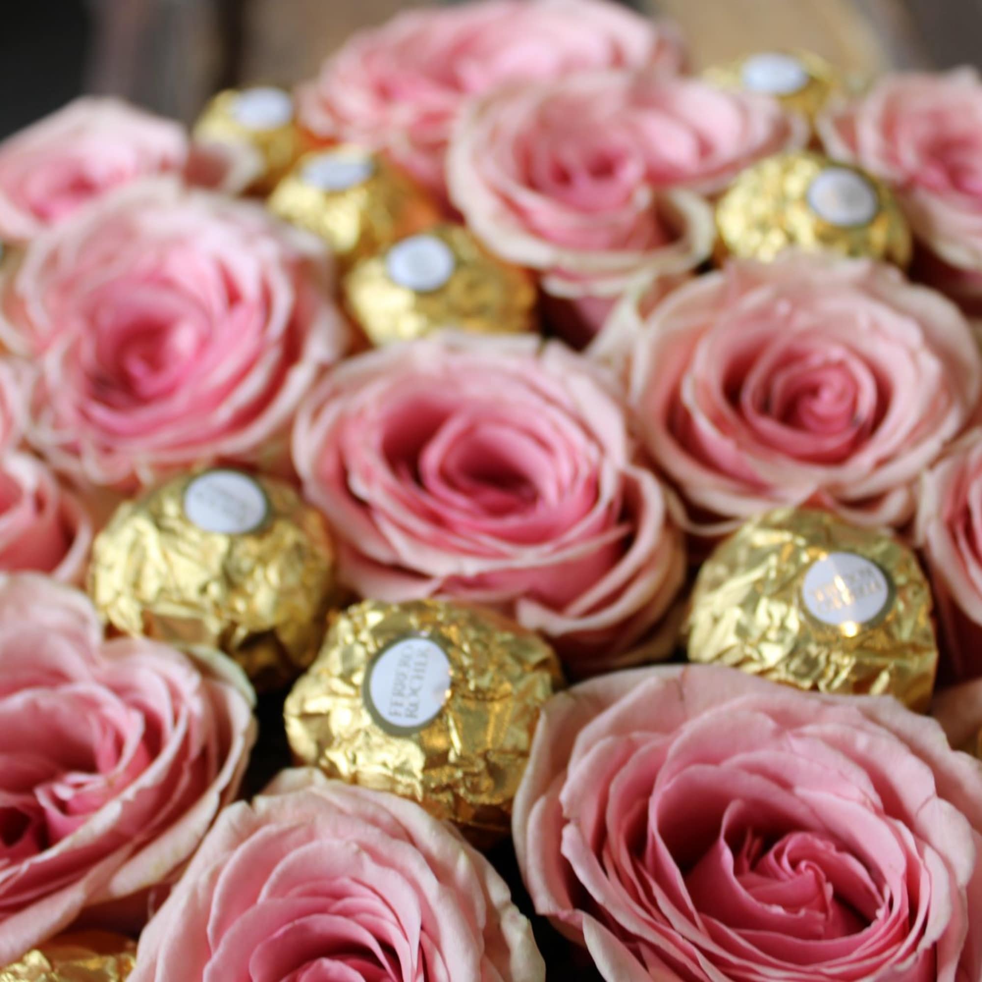 Pink roses arranged with gold-wrapped chocolates