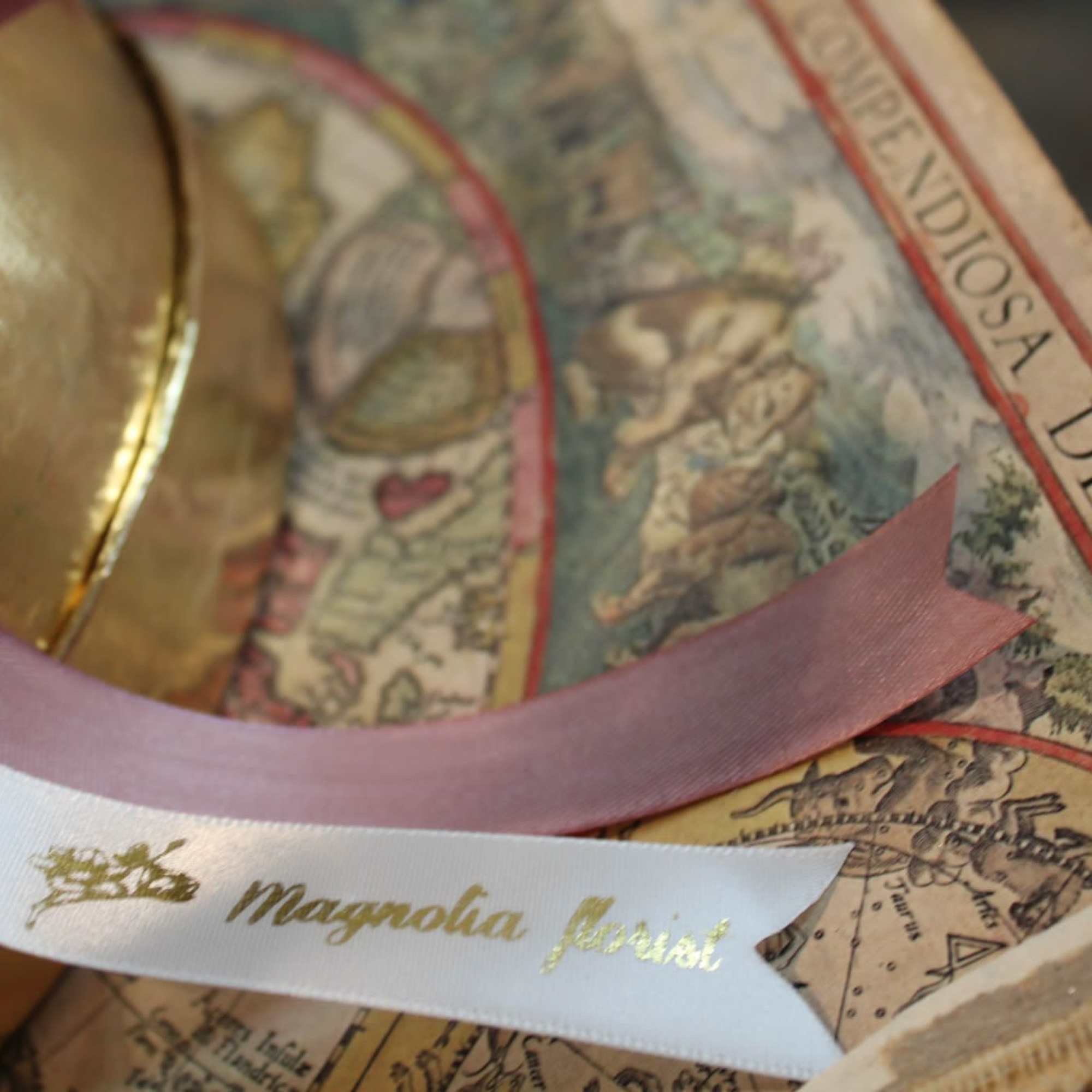 Decorative ribbon and gold ornament on a printed box