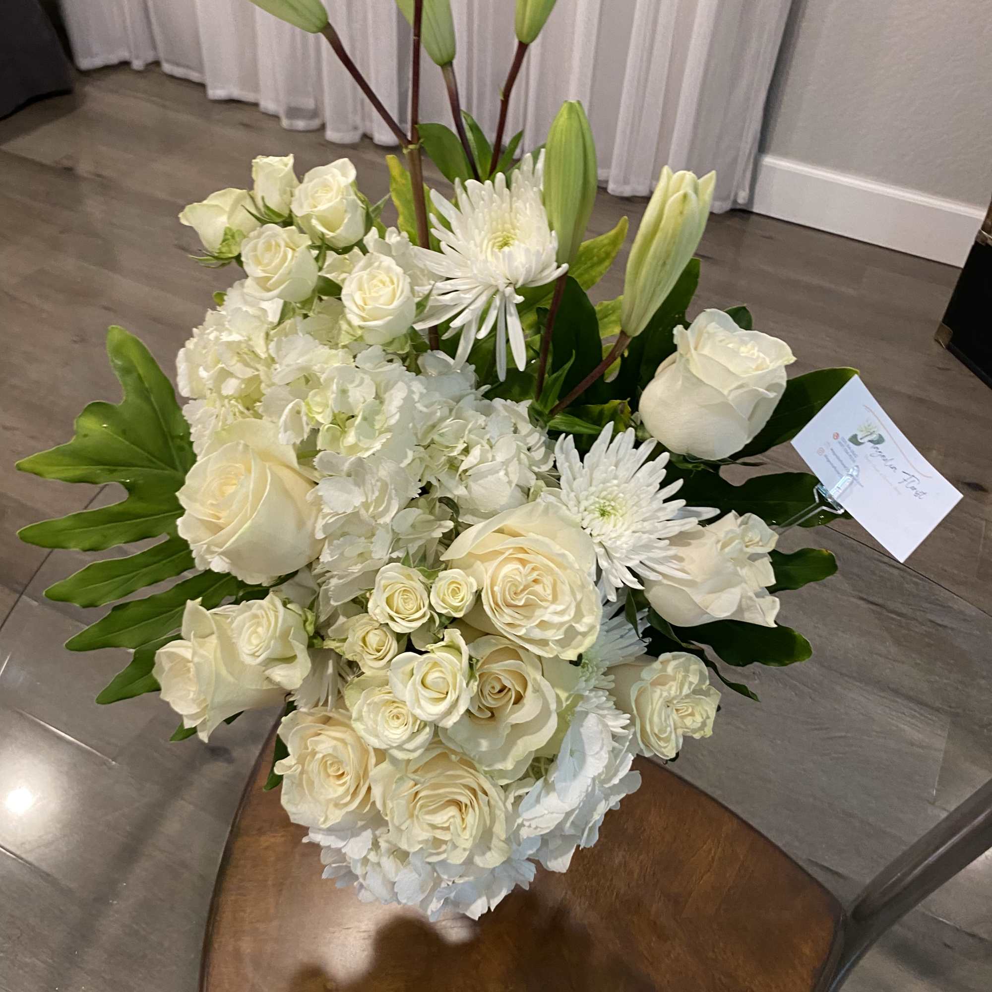 White floral arrangement with roses, lilies, and chrysanthemums