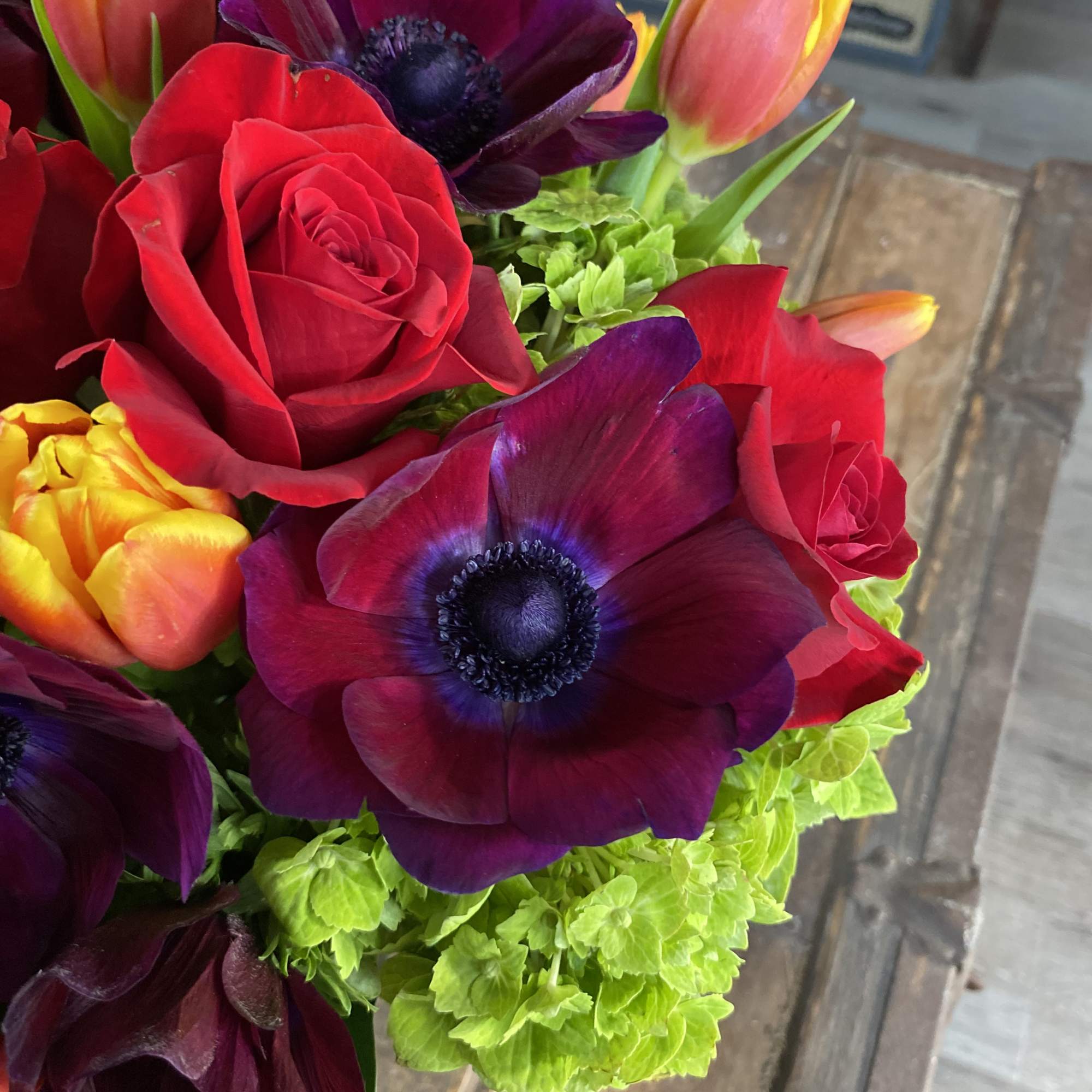 Bouquet of red roses, purple anemones, and orange tulips