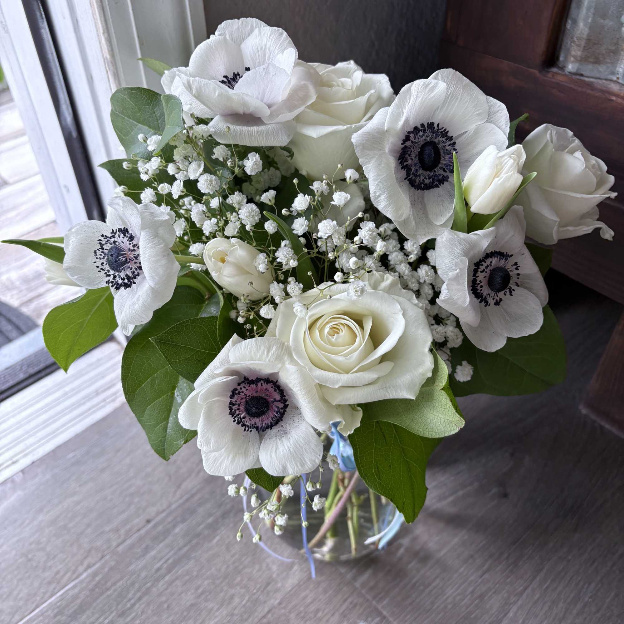 White roses and anemones in a glass vase