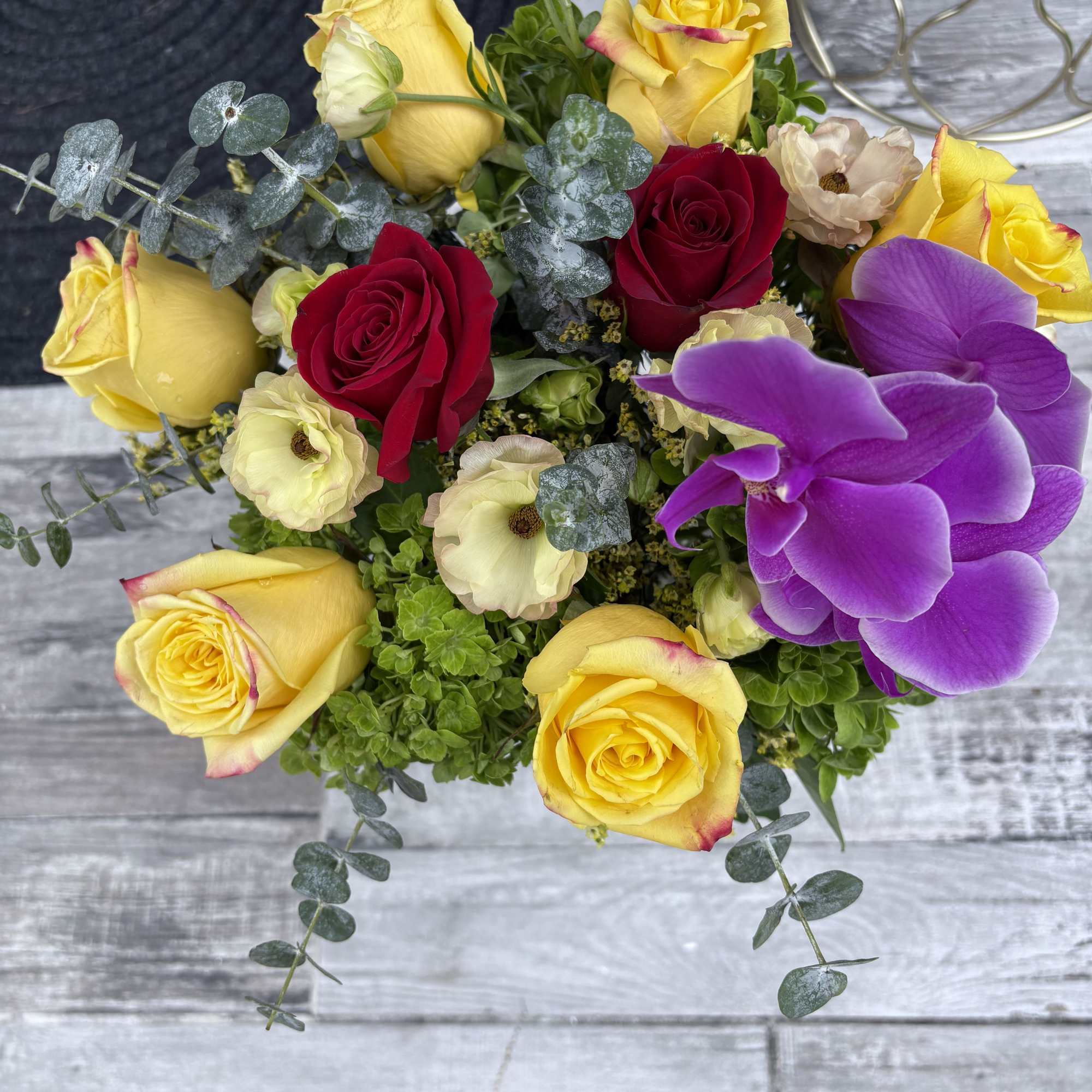 Bouquet of yellow and red roses with purple orchids